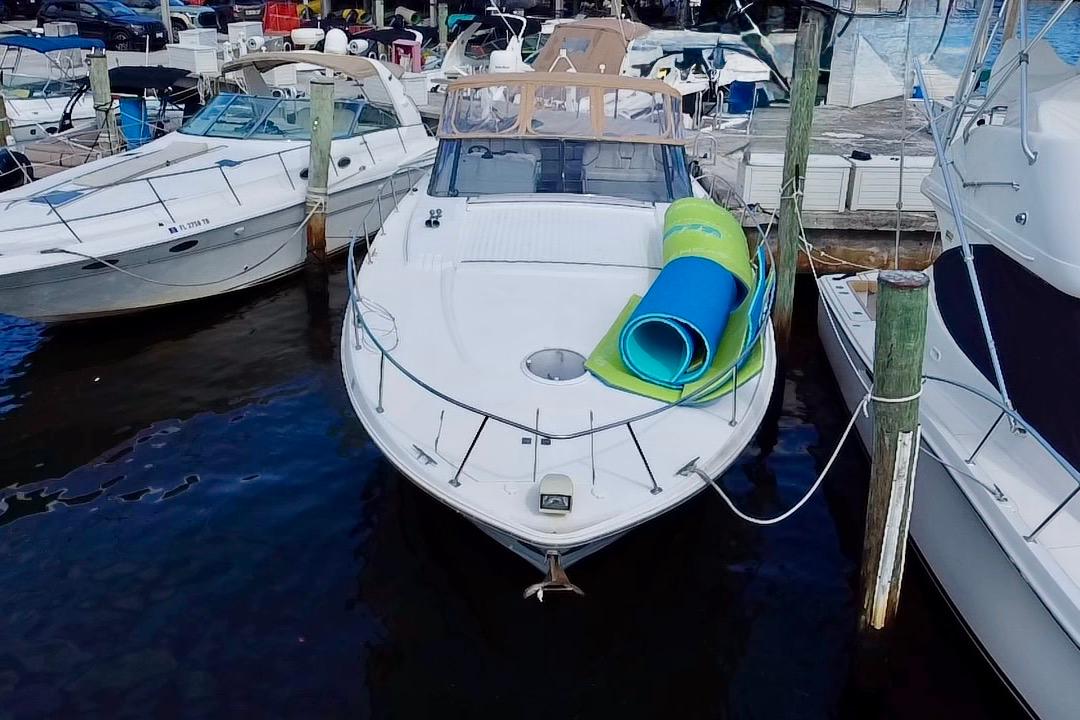 2000 Trojan 440 Express yacht docked with rolled mats on deck.