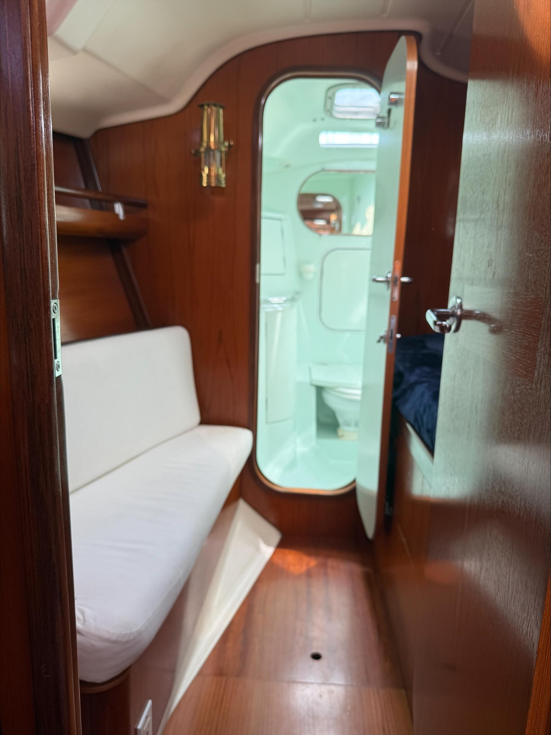 Interior of 1993 Beneteau Oceanis 400 sailboat, featuring cozy seating and wooden finishes.