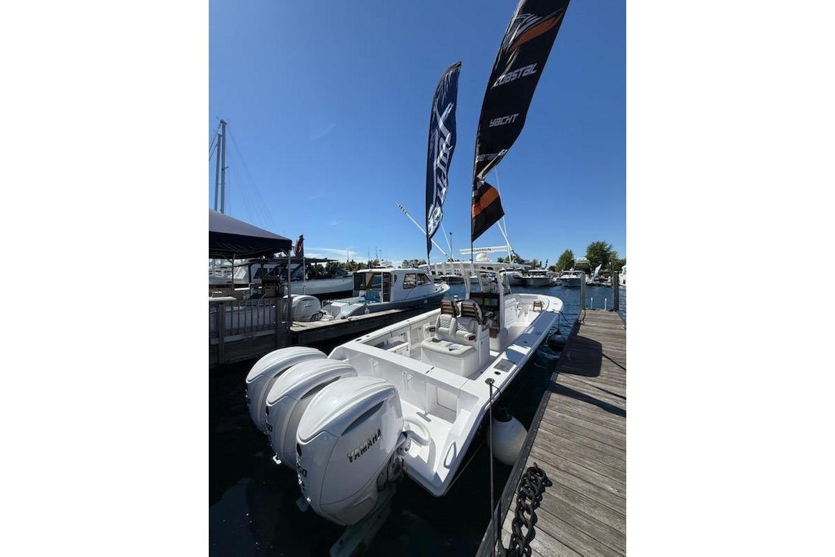 2026 Jupiter 340LS boat docked with dual Yamaha engines and flags waving.