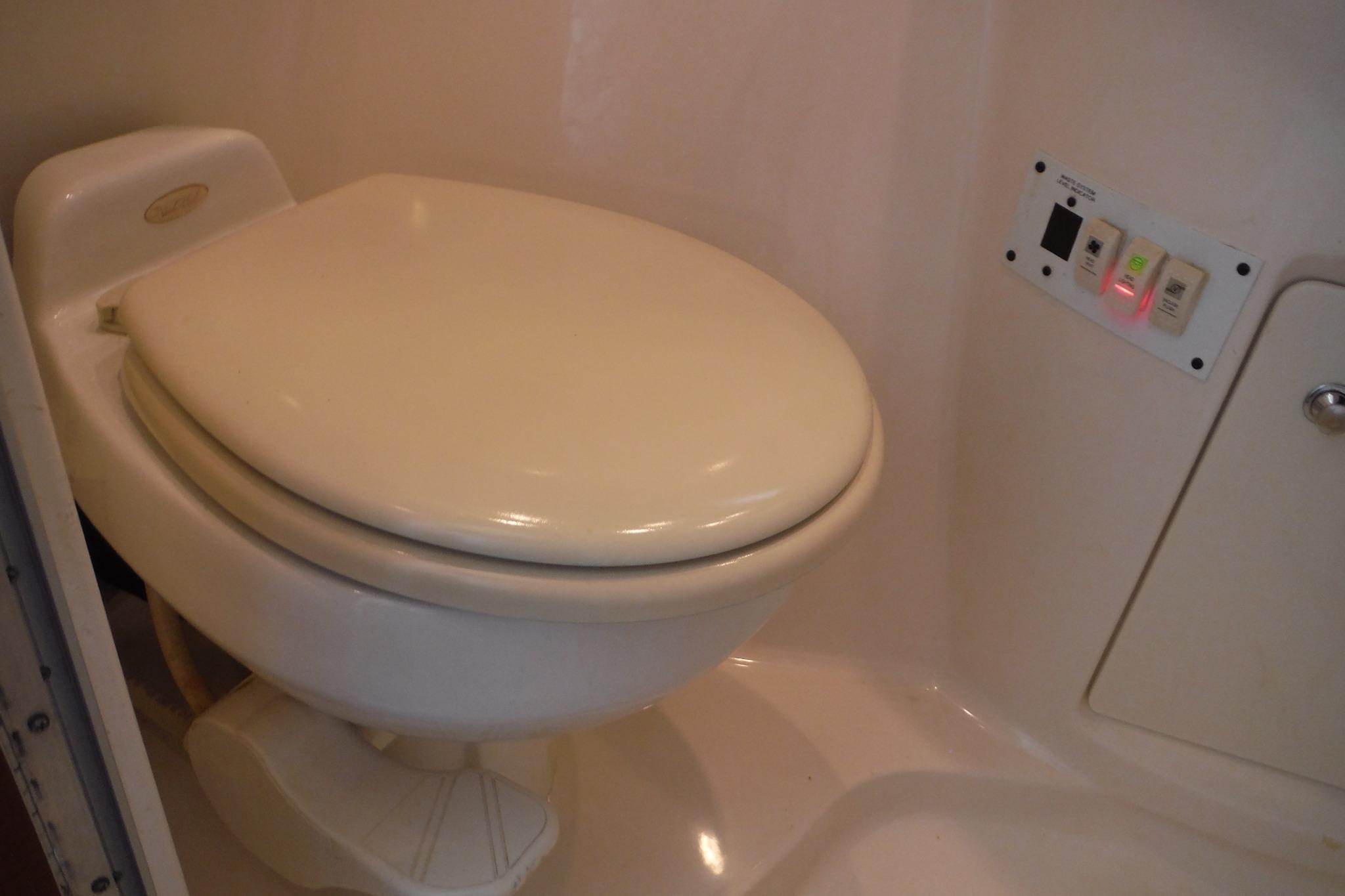 2005 Chaparral Signature 350 boat bathroom with toilet and control panel.