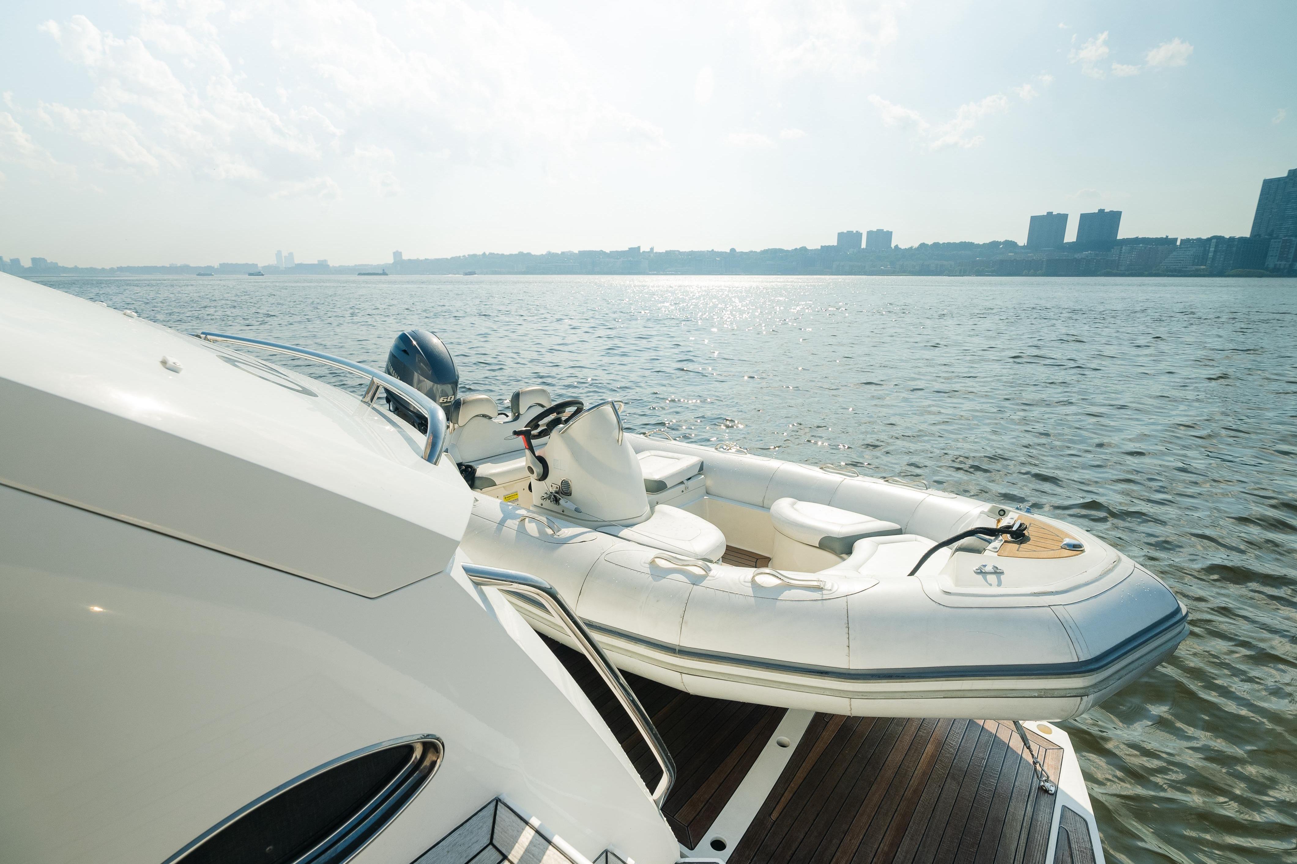 Luxury Sunseeker Manhattan 65 yacht with tender on calm waters, 2016 model.