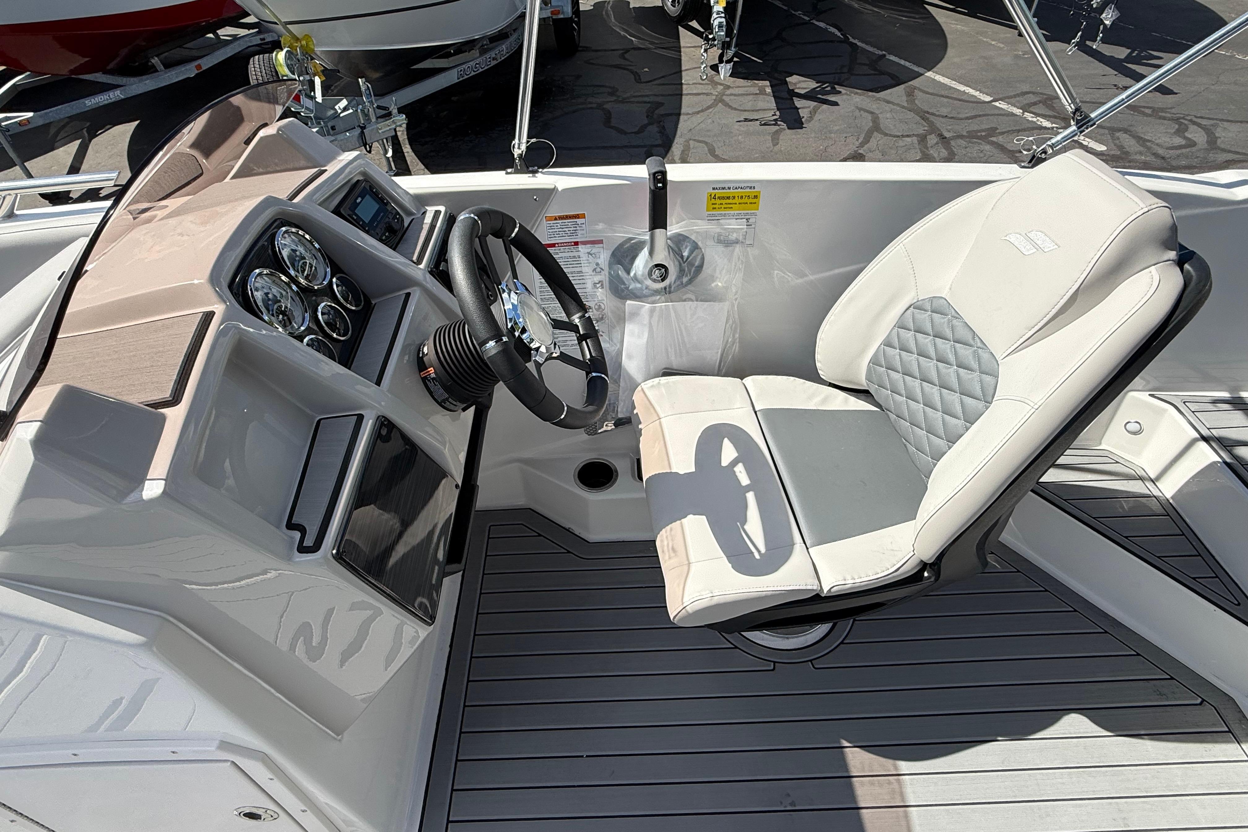 2026 Starcraft SVX 211 OB boat cockpit with steering wheel and cushioned seat.