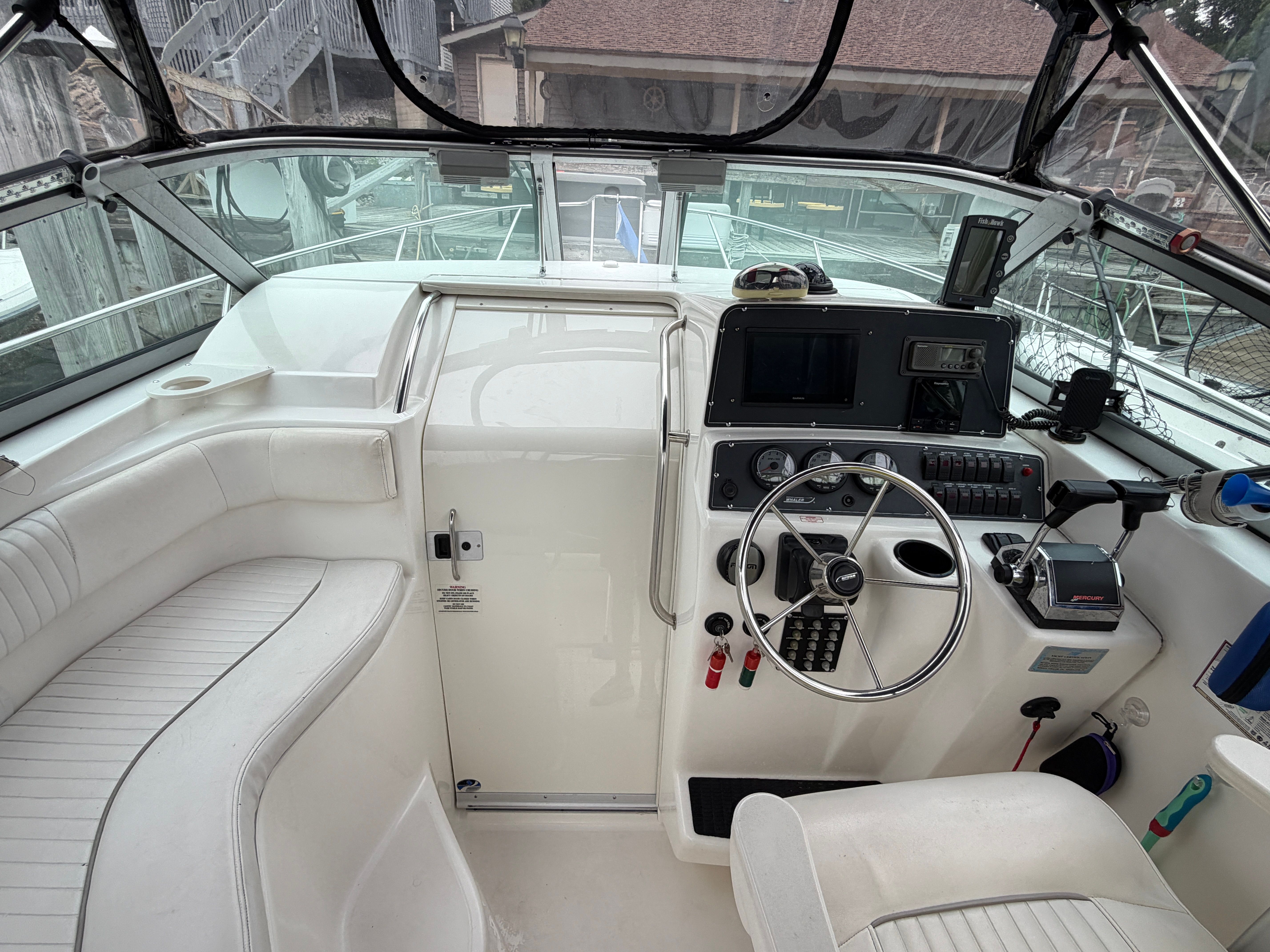 The cockpit of a 2001 Boston Whaler 26 Conquest with helm and instruments.