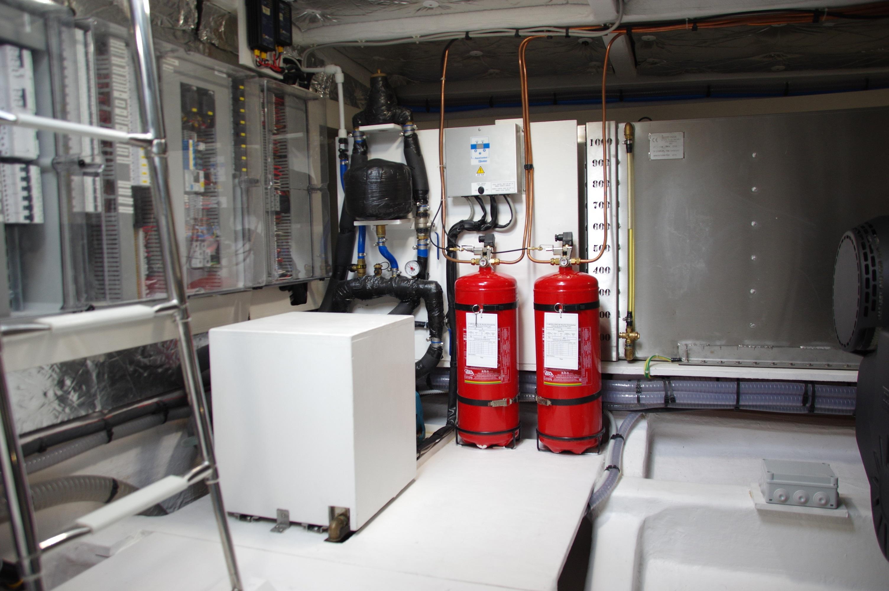 Engine room of 2025 Pardo Yachts 50, featuring fire extinguishers and control systems.