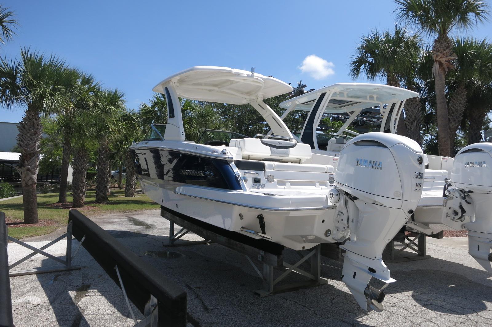 2025 Chaparral 270 OSX boat with Yamaha engines, displayed outdoors near palm trees.