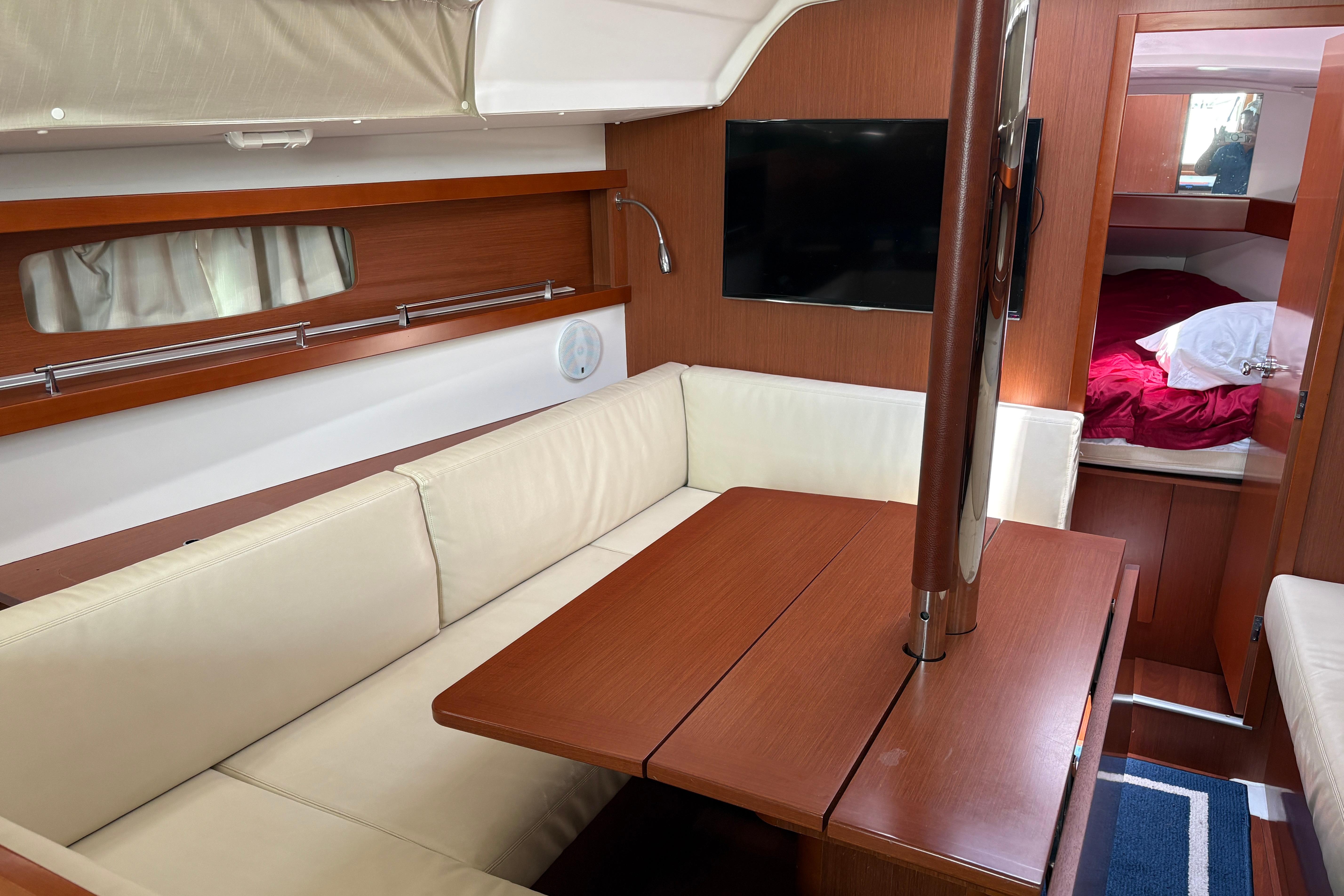 Interior of 2015 Beneteau Oceanis 34 yacht with cozy seating and modern amenities.
