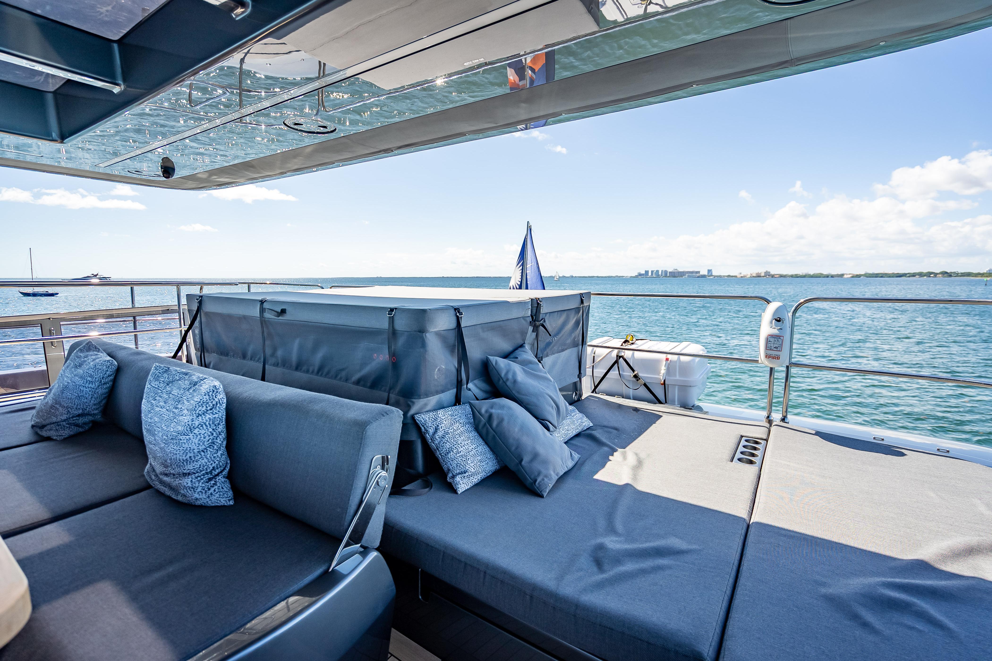 Luxurious Sunreef 60 Power yacht deck with comfortable seating, ocean view, and clear skies.