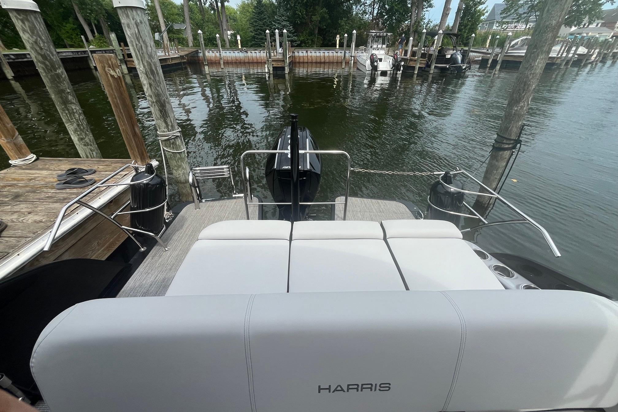 2024 Harris Grand Mariner 250 pontoon boat docked at a serene marina.
