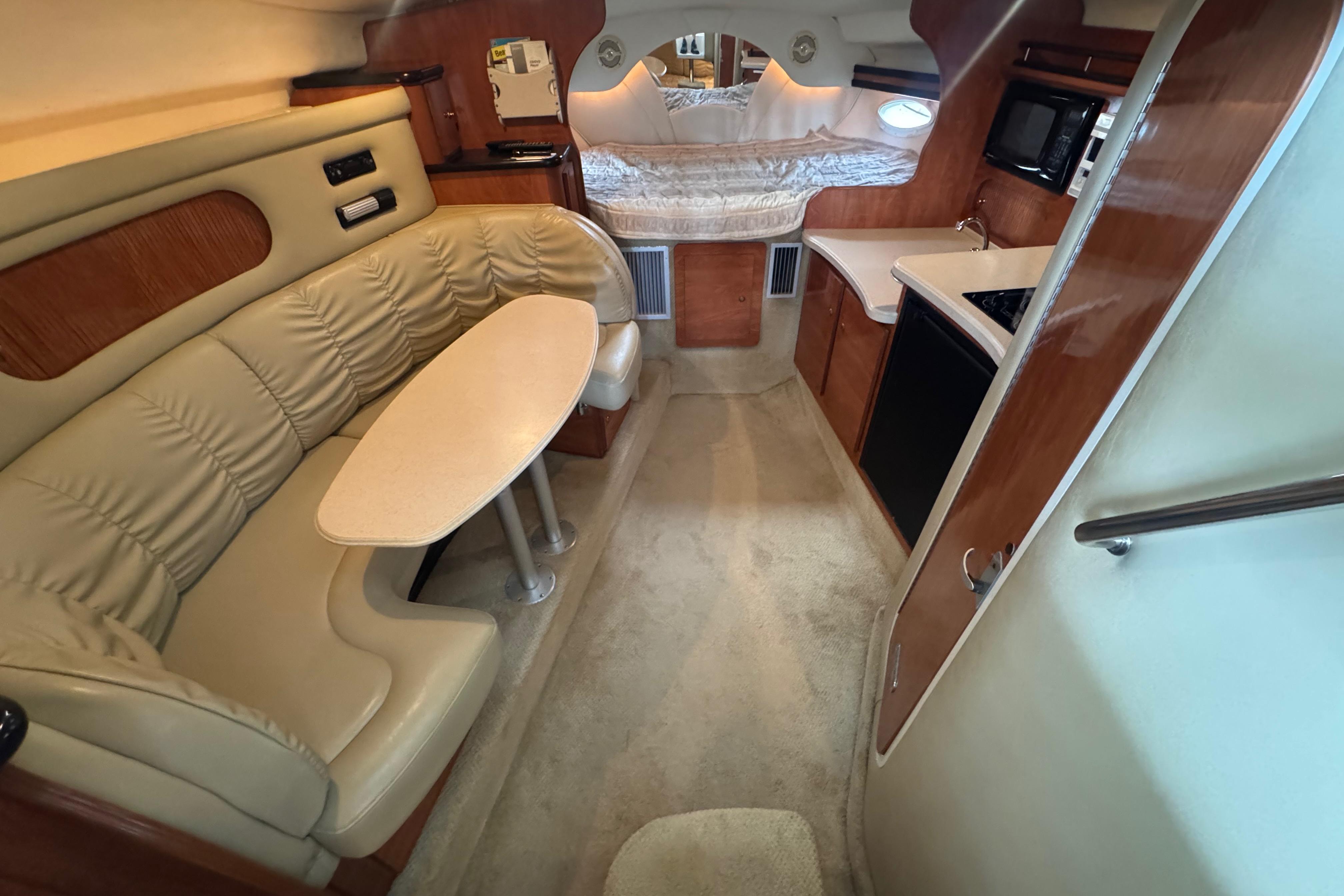 2004 Rinker Fiesta Vee 312 cabin interior with seating, kitchenette, and sleeping area.