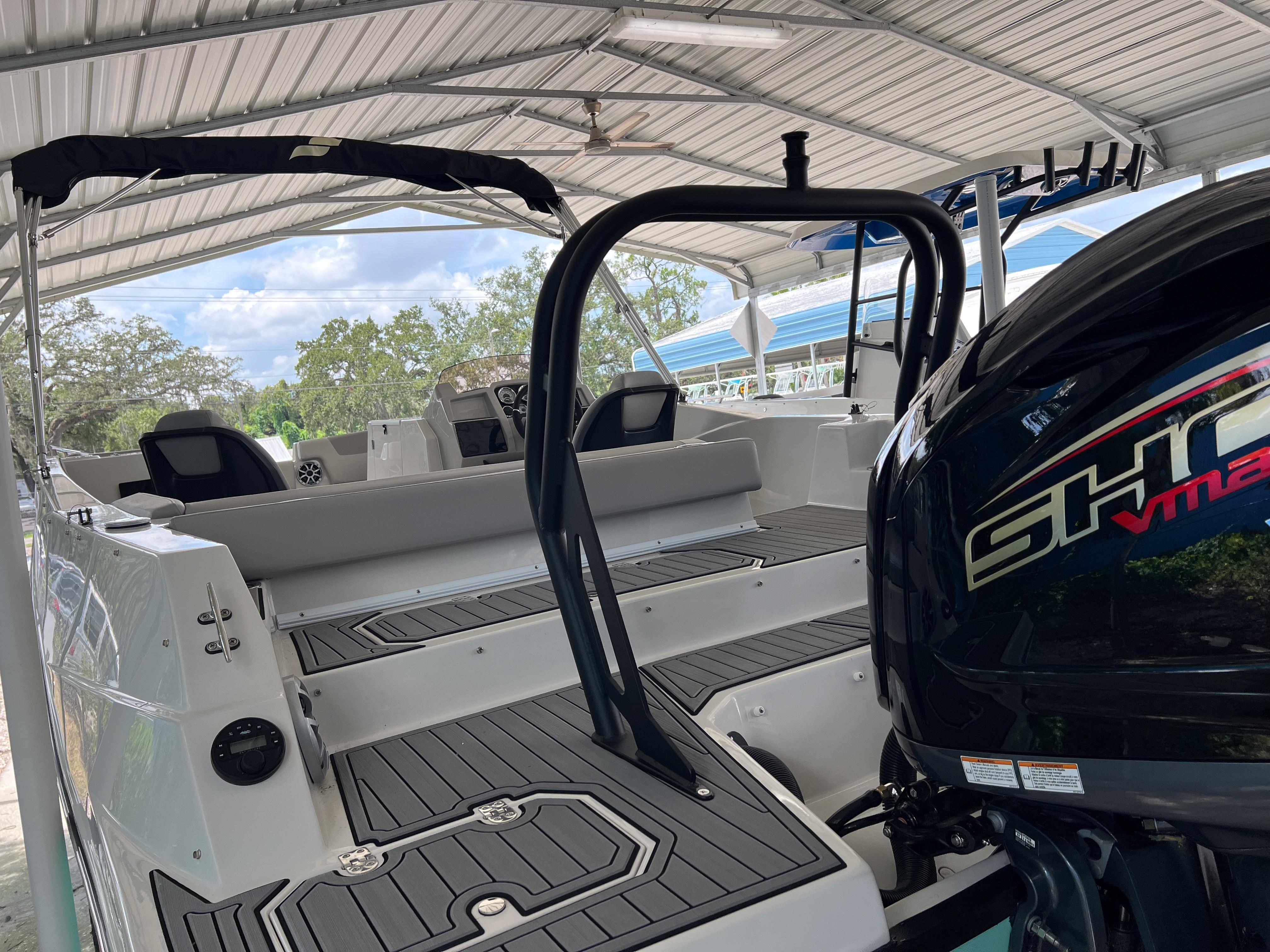 2026 Starcraft SVX 231 OB boat under a canopy, featuring sleek interior and powerful engine.