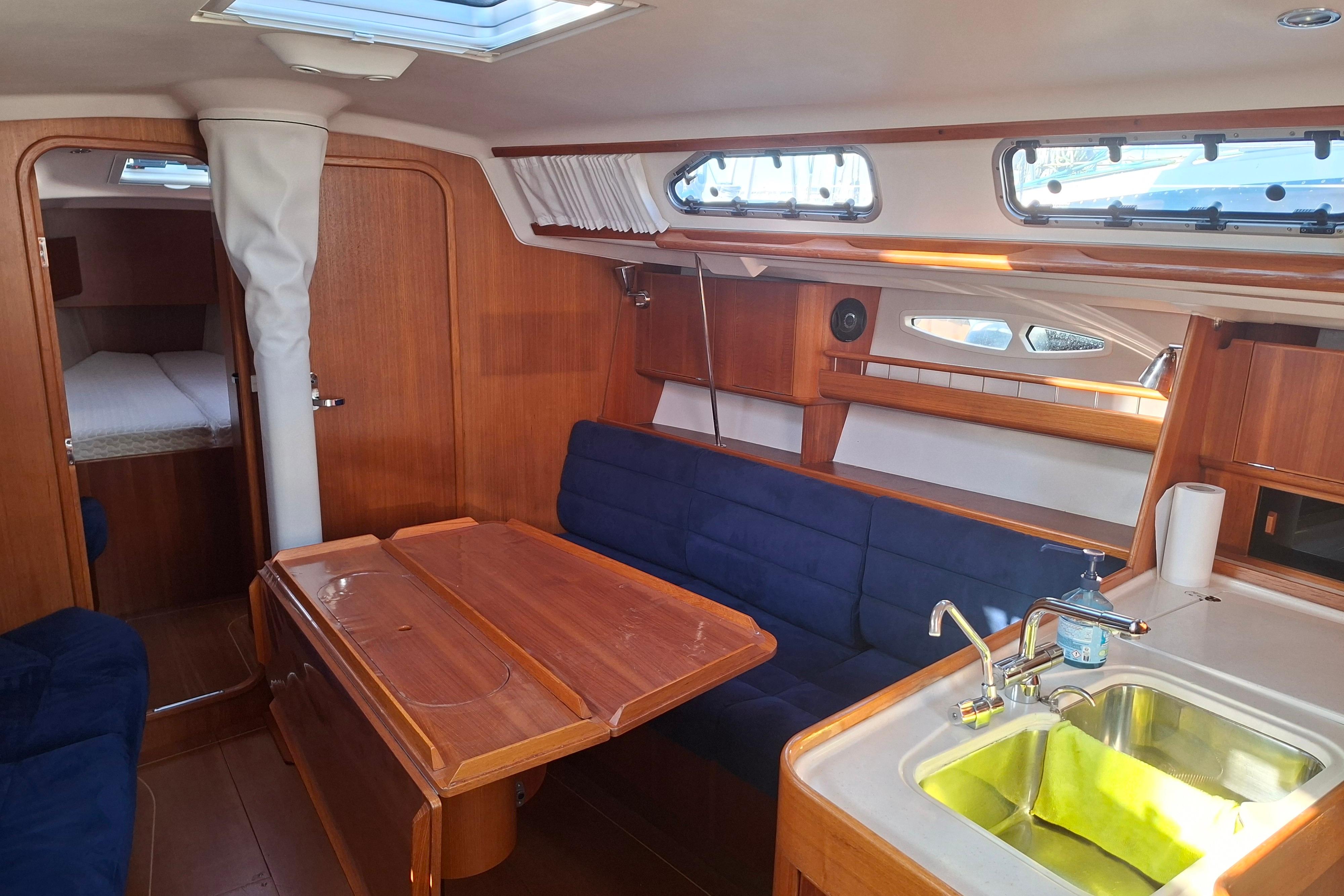 Interior of 2006 Xyachts X 40 sailboat with wooden furnishings and blue seating.
