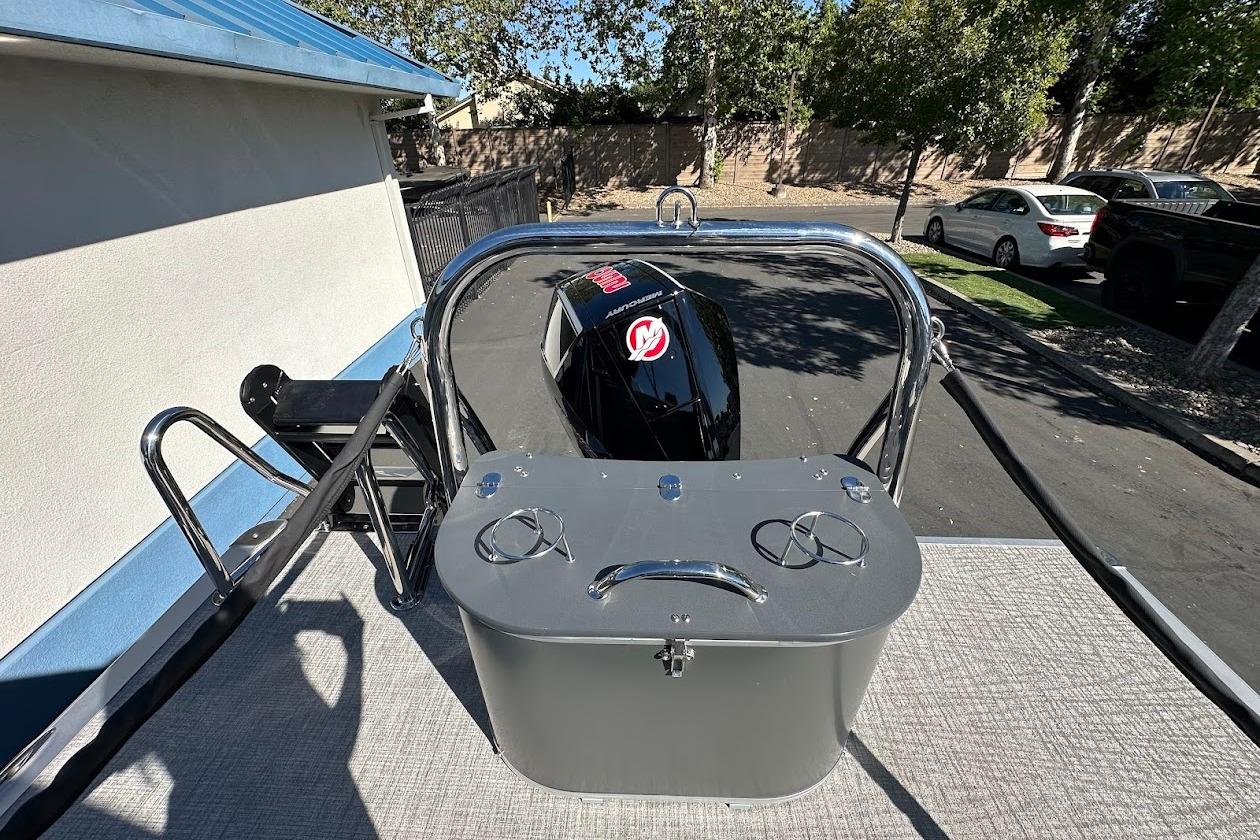 2026 Tahoe Pontoon LTZ Quad Lounger Shift 23 with outboard motor, parked outdoors.
