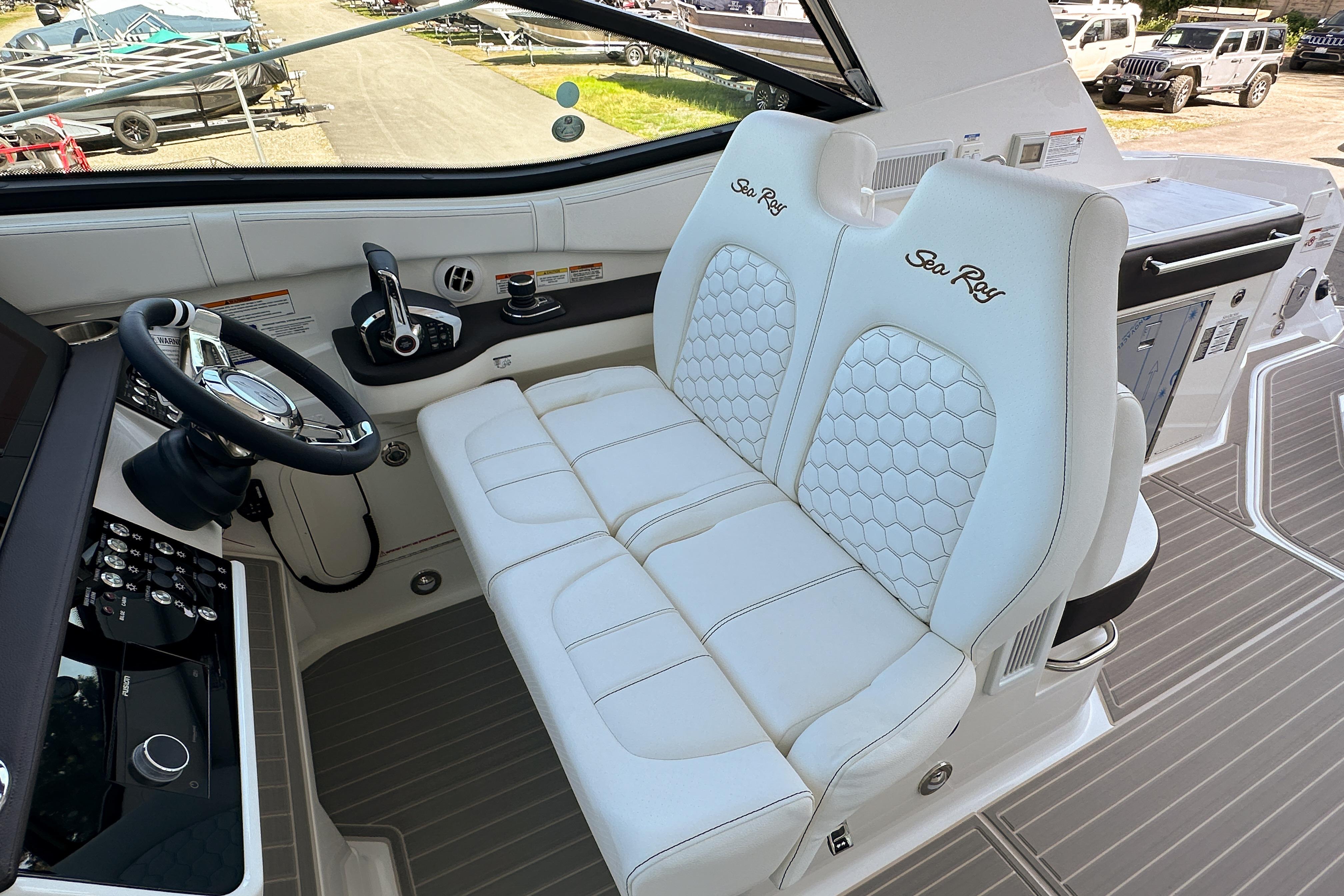 2026 Sea Ray Sundancer 320 cockpit with luxurious white seating and modern controls.