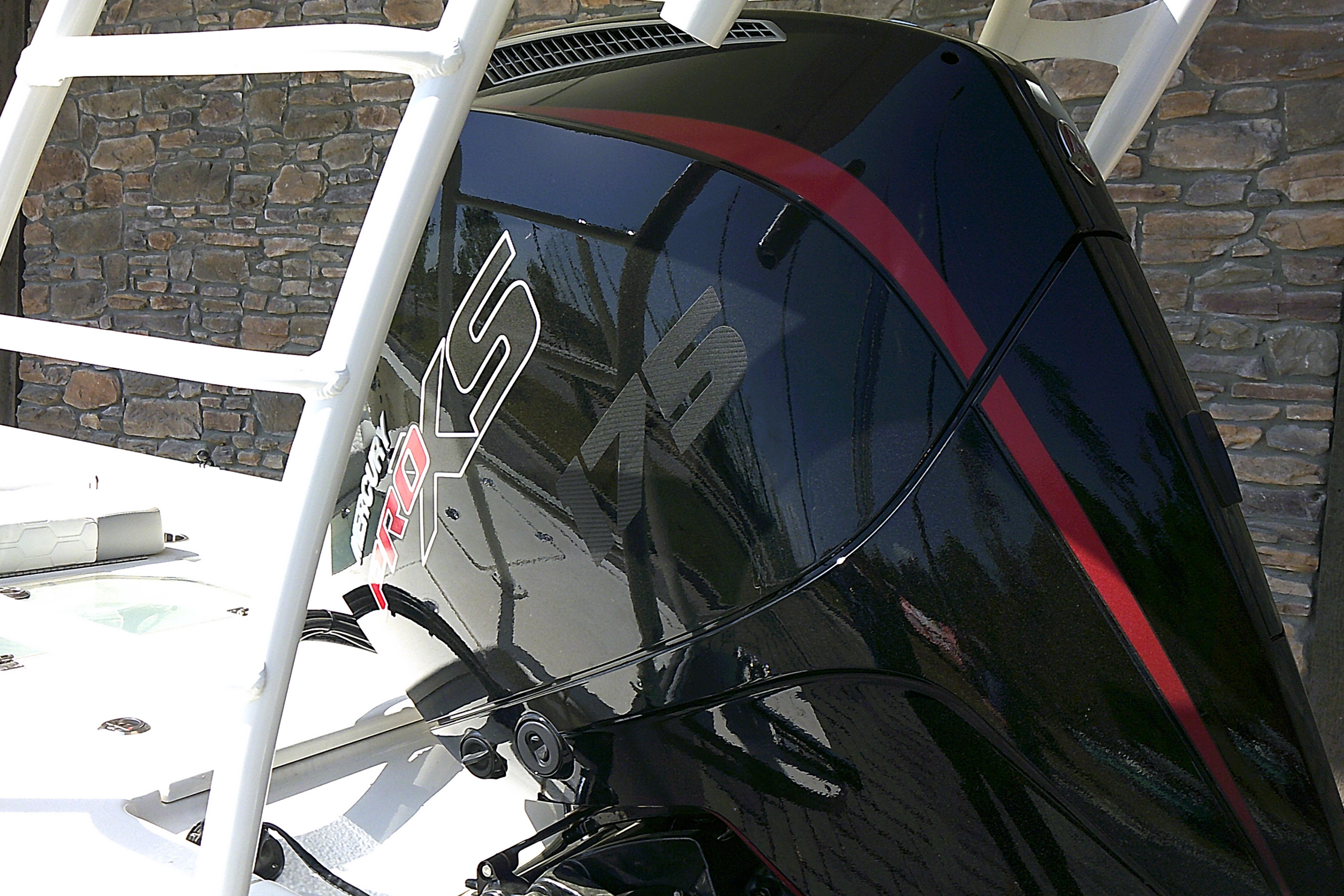 2026 Mako 18 Pro Skiff with powerful outboard motor, featuring sleek black and red design.