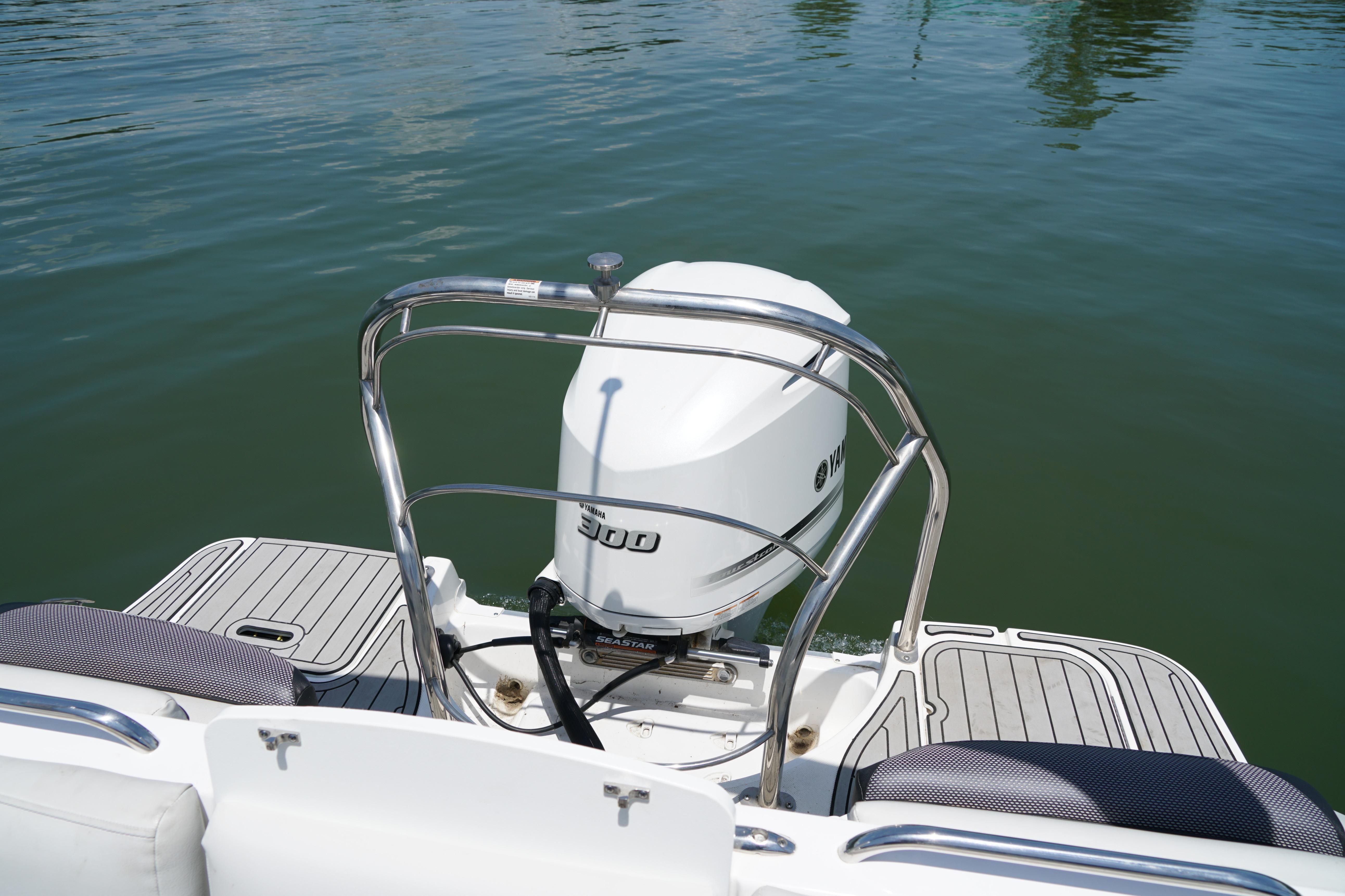 2020 Hurricane SunDeck 2486 OB boat with Yamaha outboard motor on calm water.