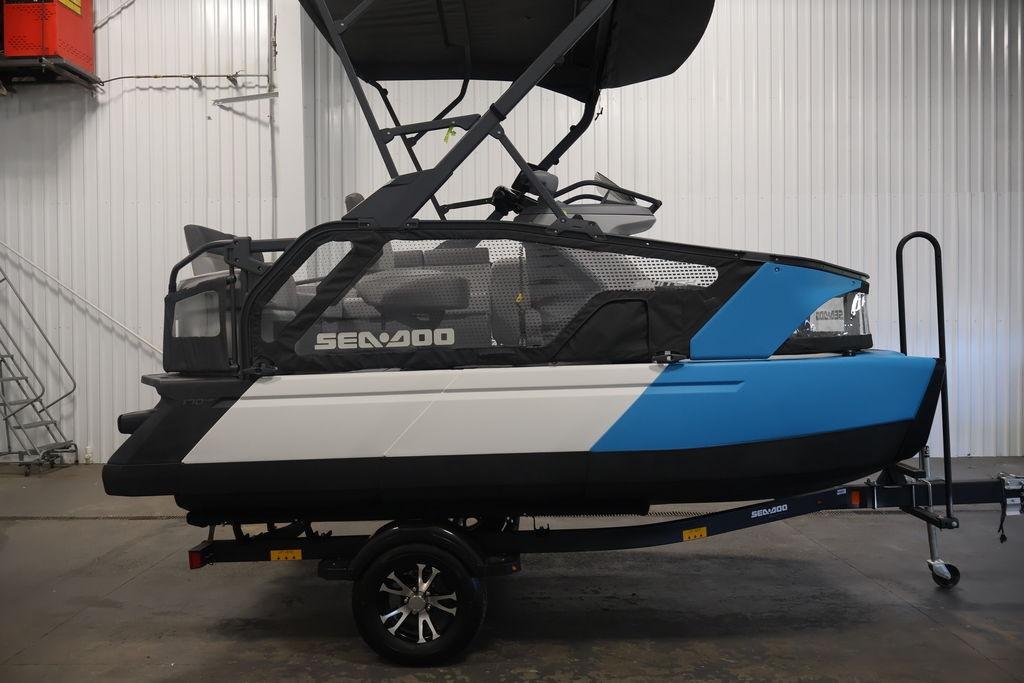 2023 Sea-Doo Switch Sport Compact in a showroom, featuring a sleek blue and white design.