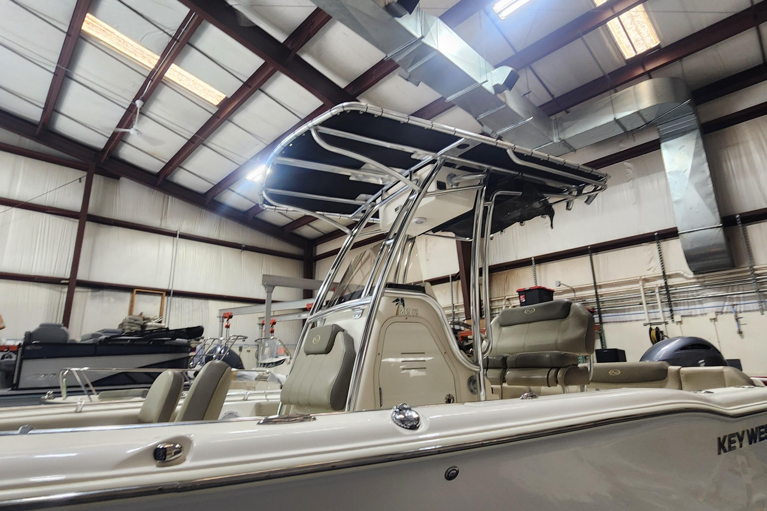 2023 Key West 219 FS boat in a warehouse, featuring sleek design and modern seating.