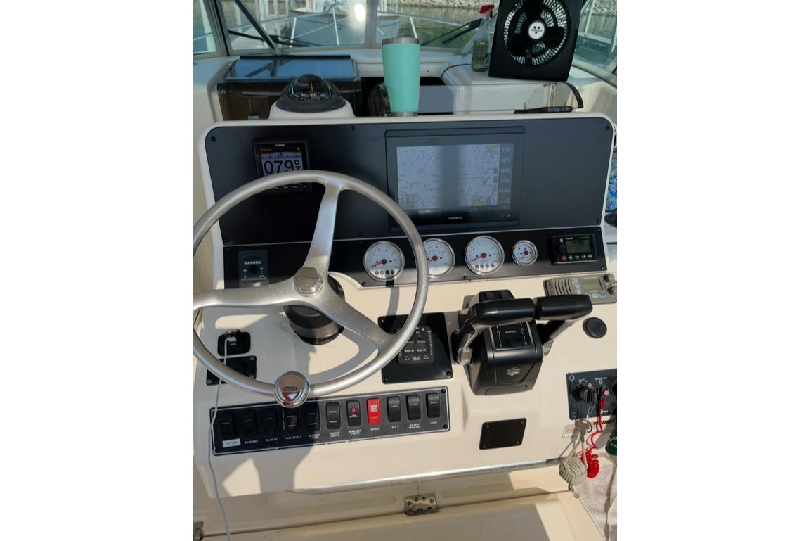 Center console of 2000 Pursuit 3070 Offshore boat with steering wheel and controls.