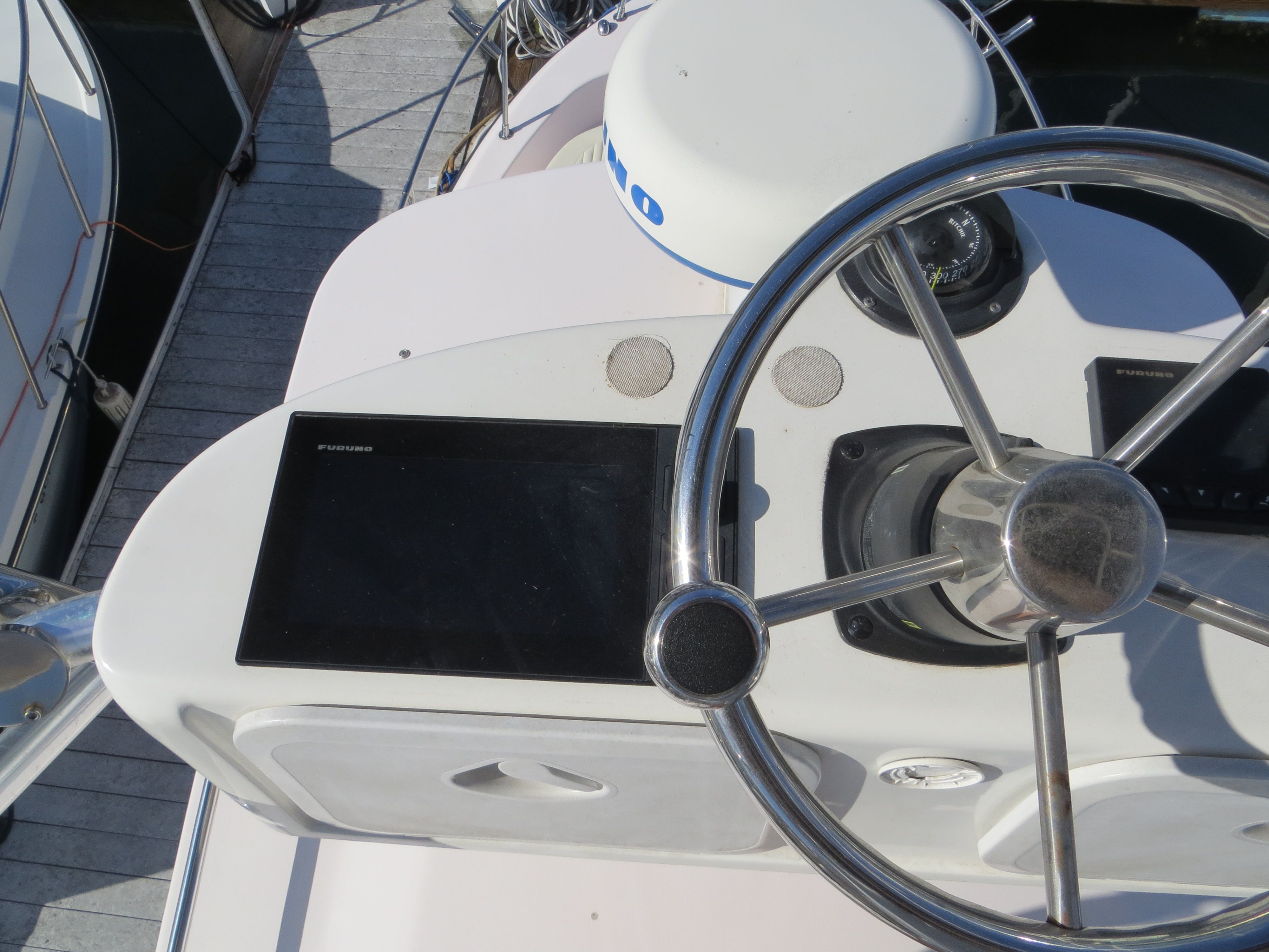Helm of a Grady-White Sailfish 282 with steering wheel and electronics.