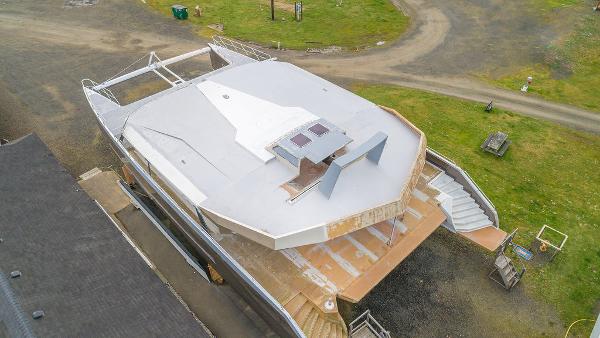 Aerial view of a 2025 Catamaran Bloomfield 86 Motorsailor under construction on land.