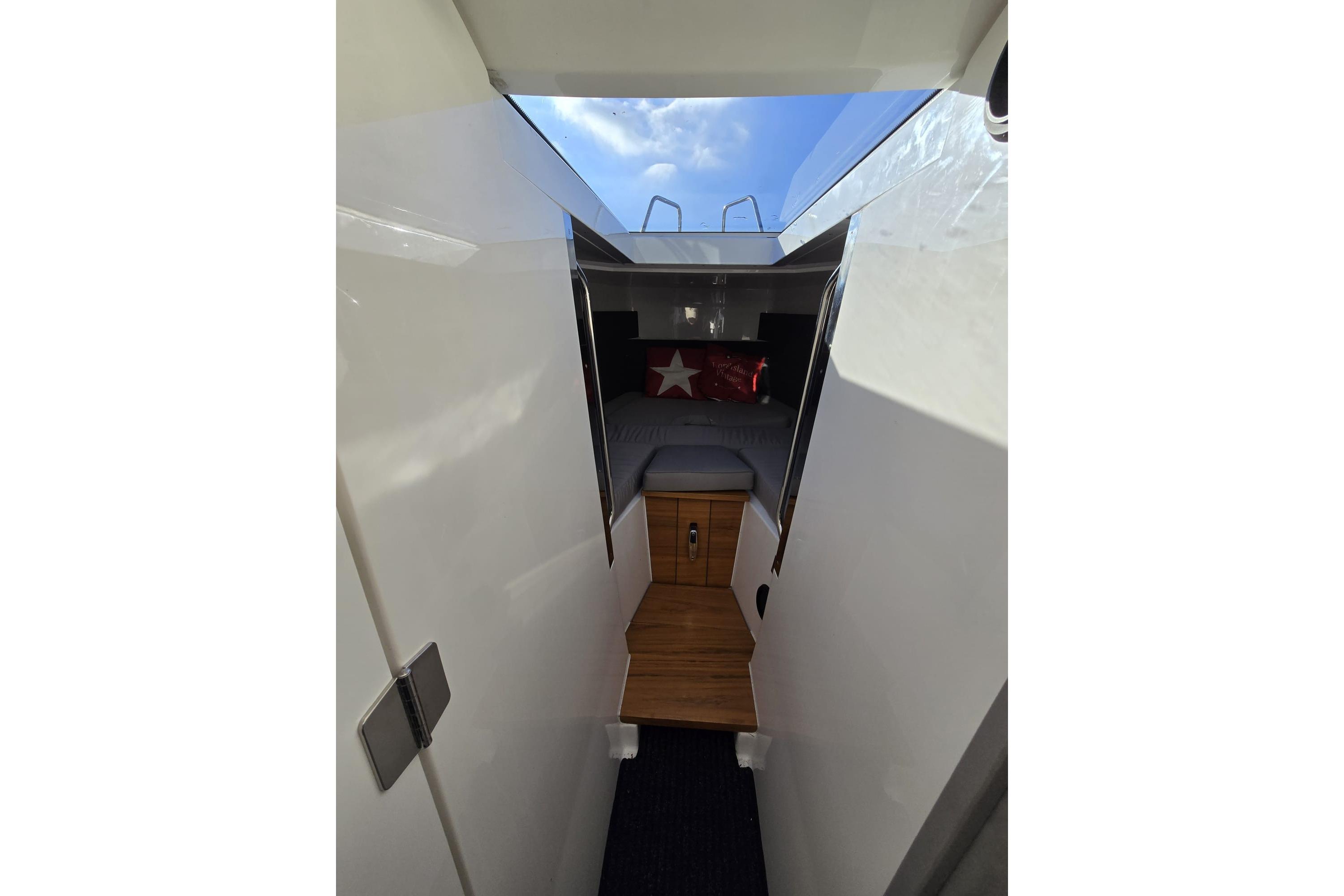 Interior cabin view of 2016 XO Boats 270 RS with wooden flooring and skylight.