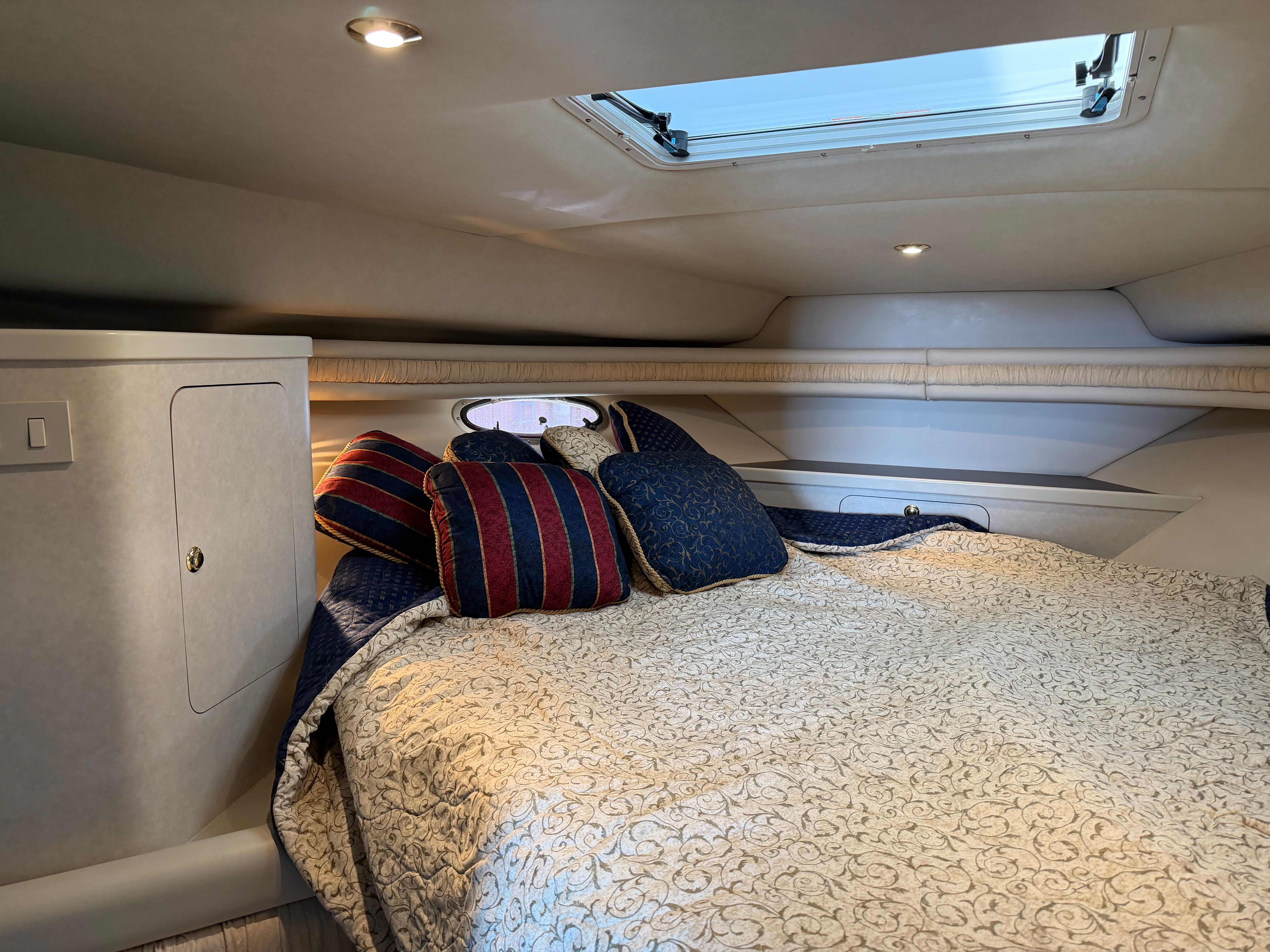 Interior of a 1997 Regal Commodore with cozy bed and skylight.
