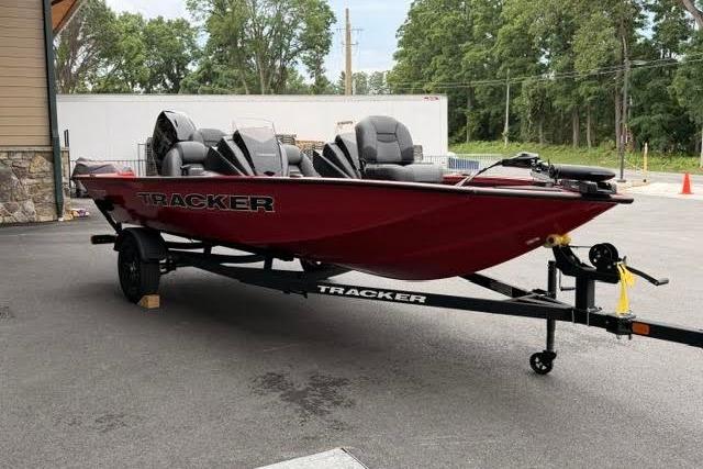2026 Tracker Pro Team 175 boat in red, parked on a trailer outdoors.