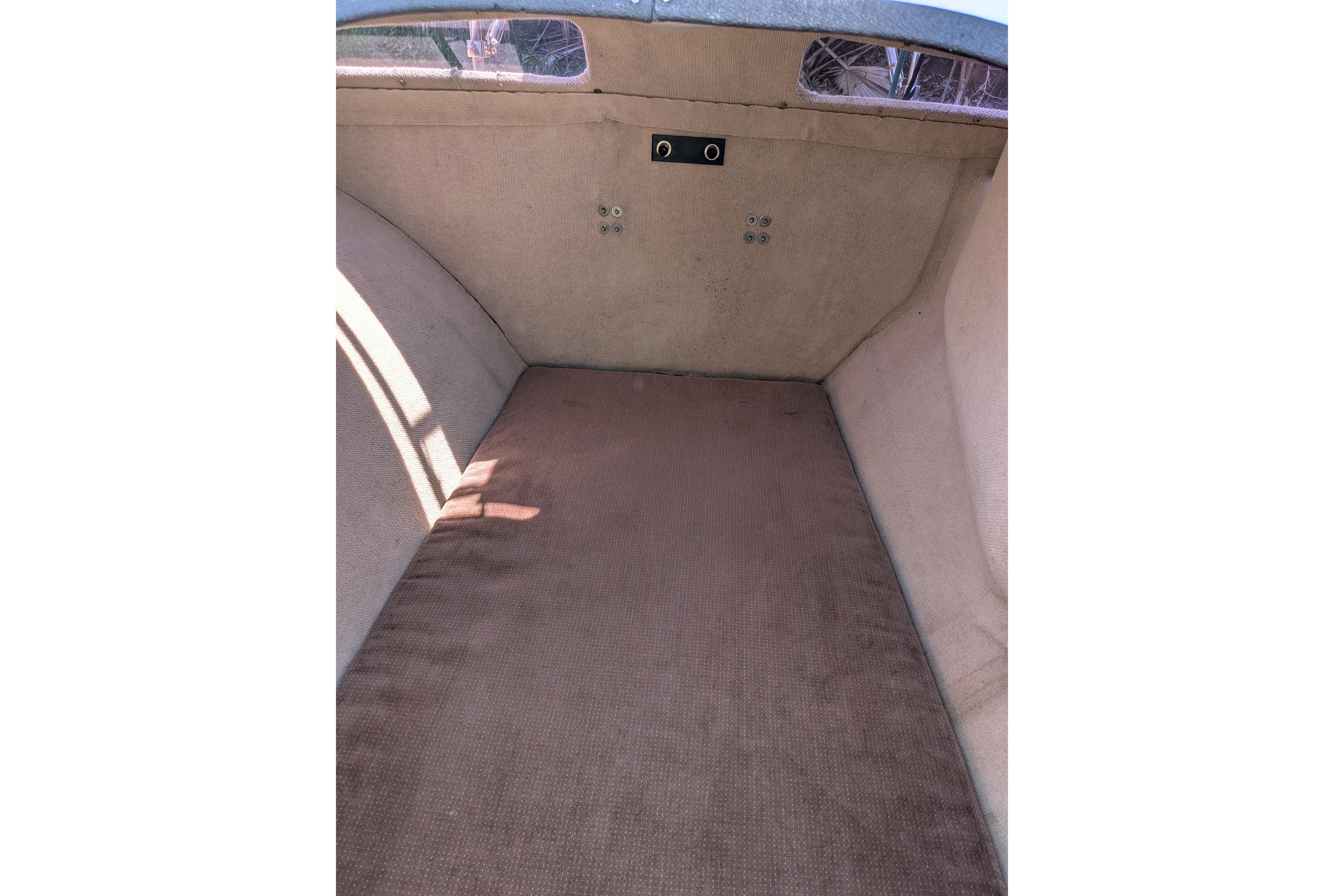 Interior cabin of a 1991 Corsair F-27 sailboat, featuring a simple, carpeted space.