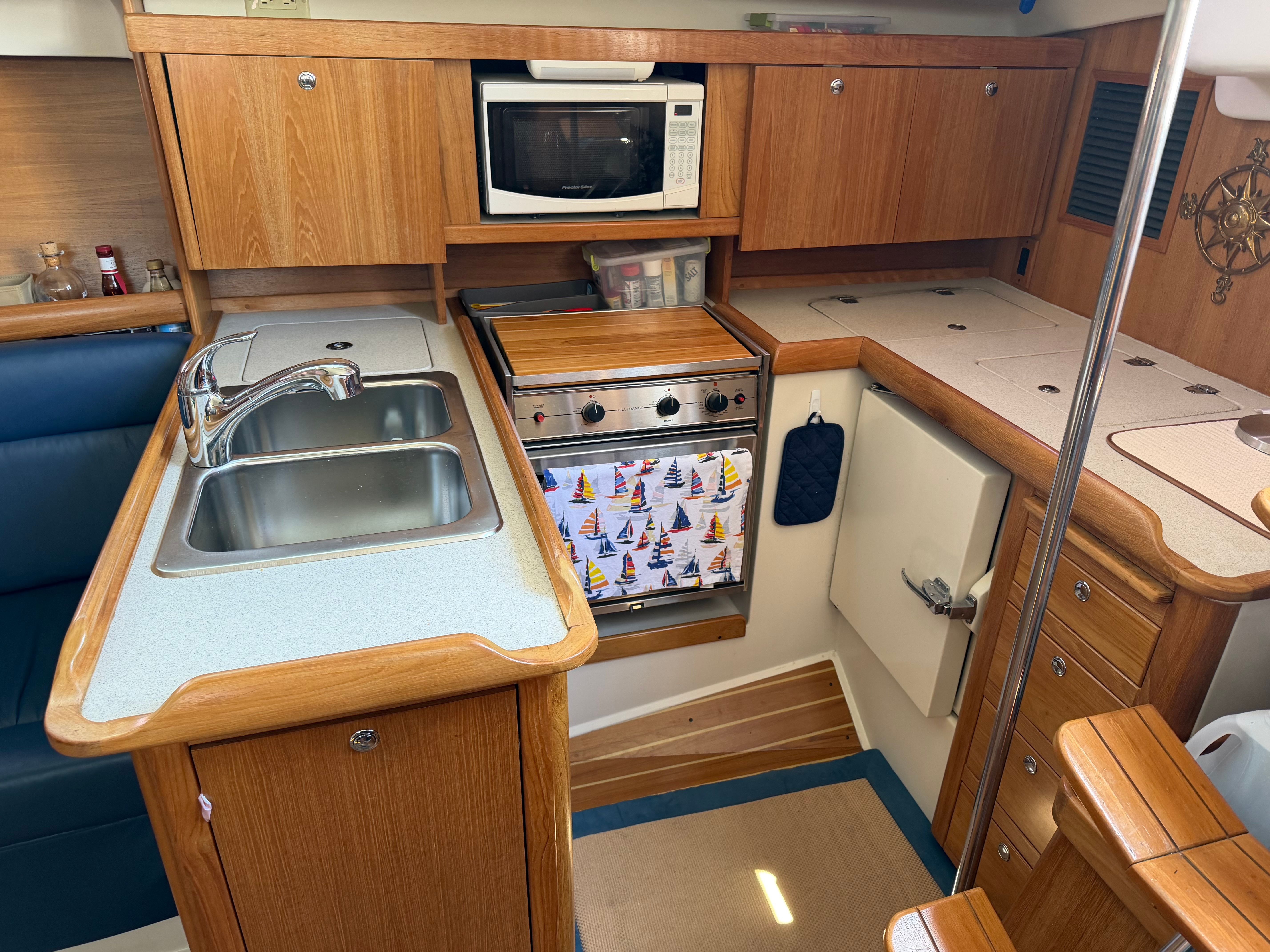 Interior of a Catalina 350 yacht with kitchen, sink, stove, and microwave.