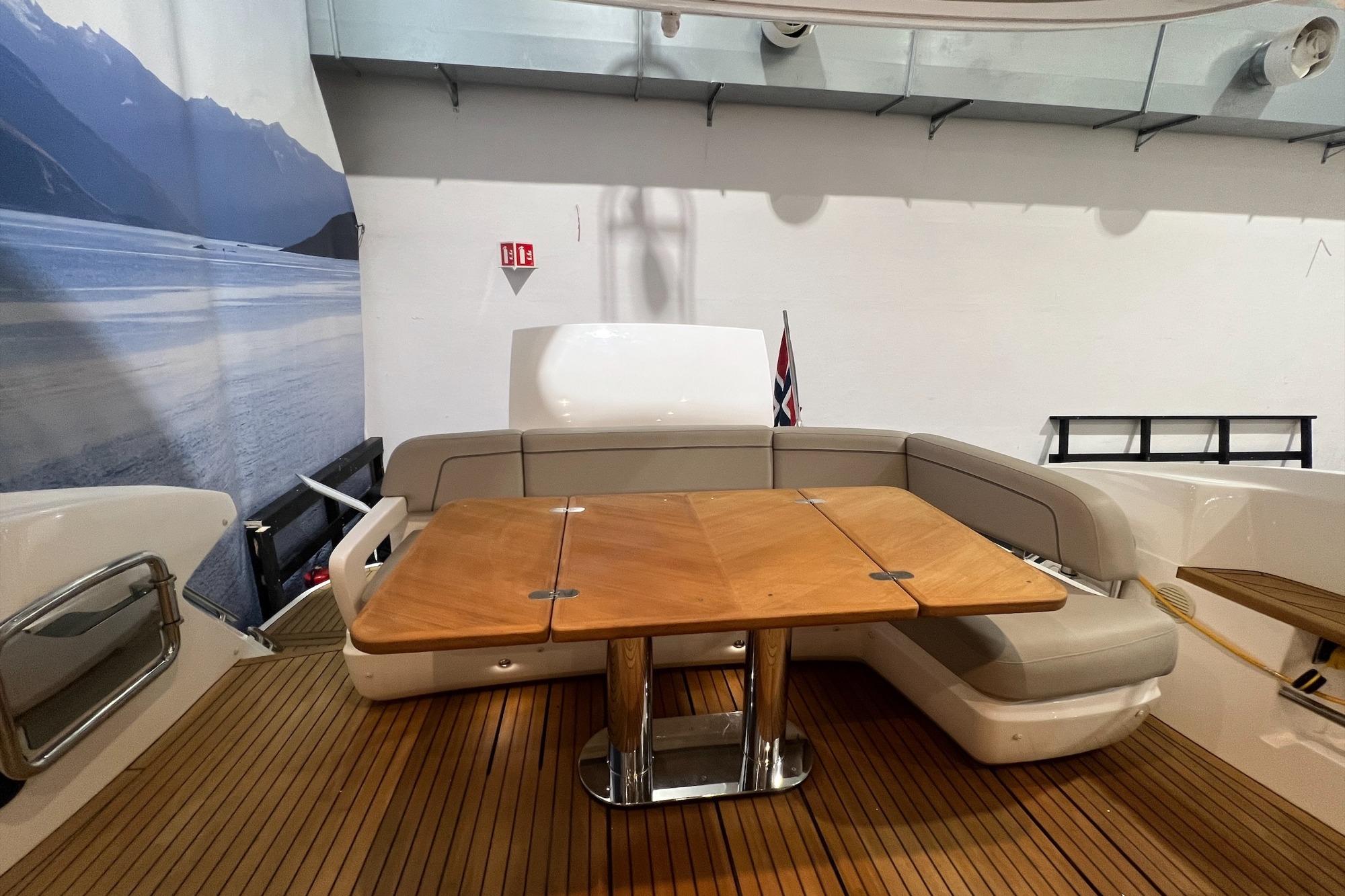 Luxurious 2019 Princess F45 yacht interior with wooden table and cushioned seating.