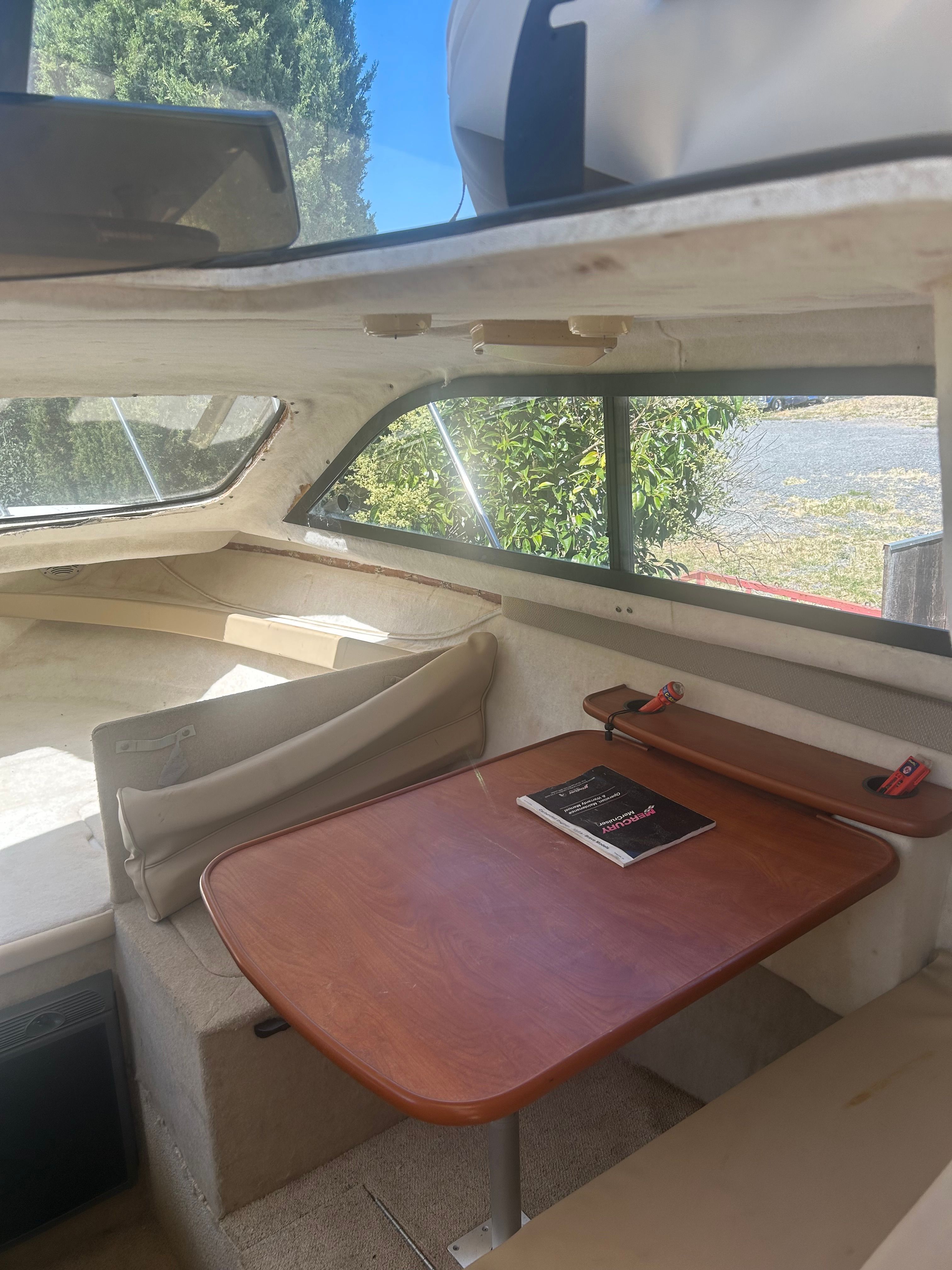Interior of a 2005 Bayliner Classic 242 with table and seating area.