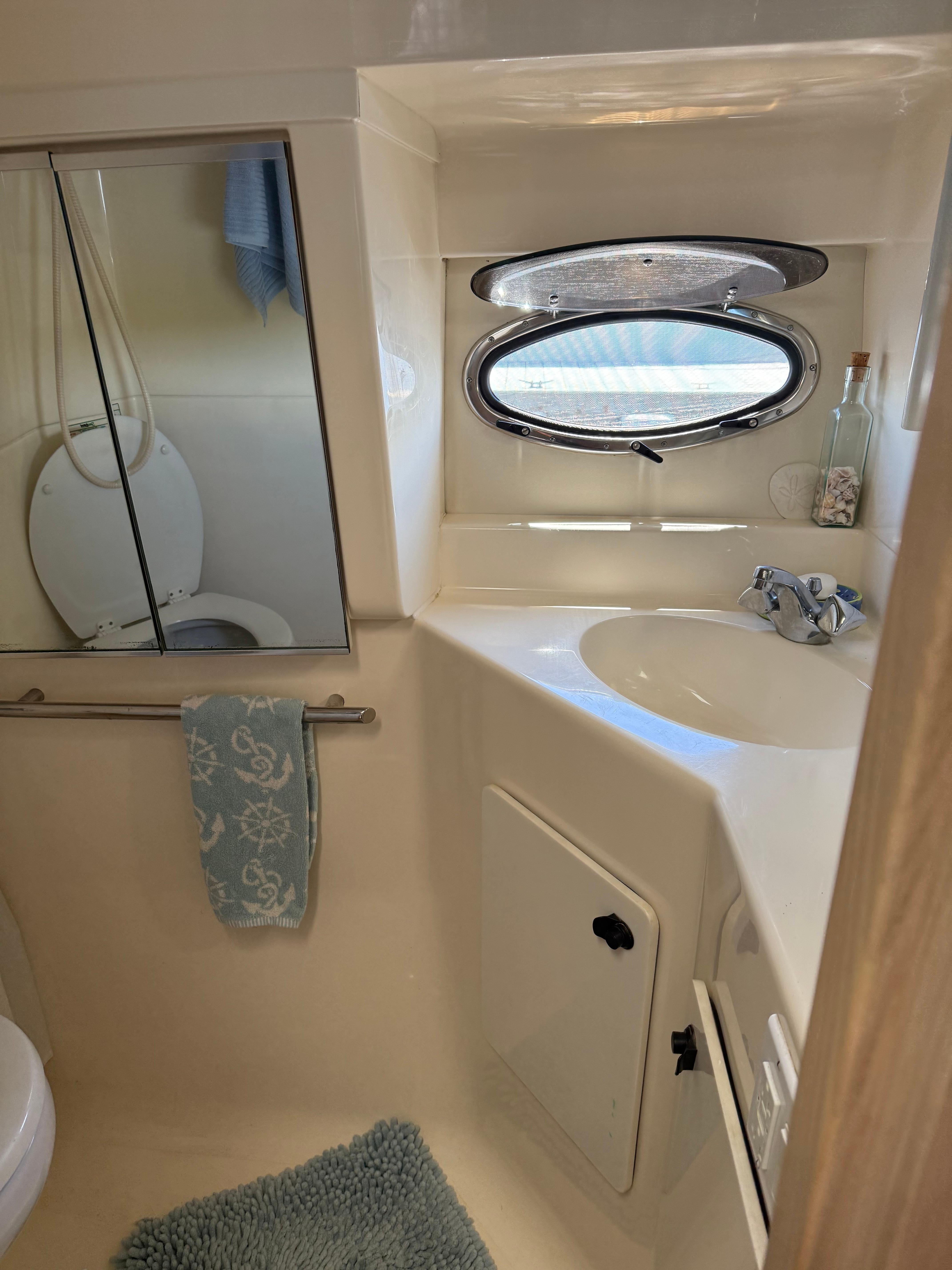 1996 Tiara Yachts 3500 Express bathroom with porthole and sink.