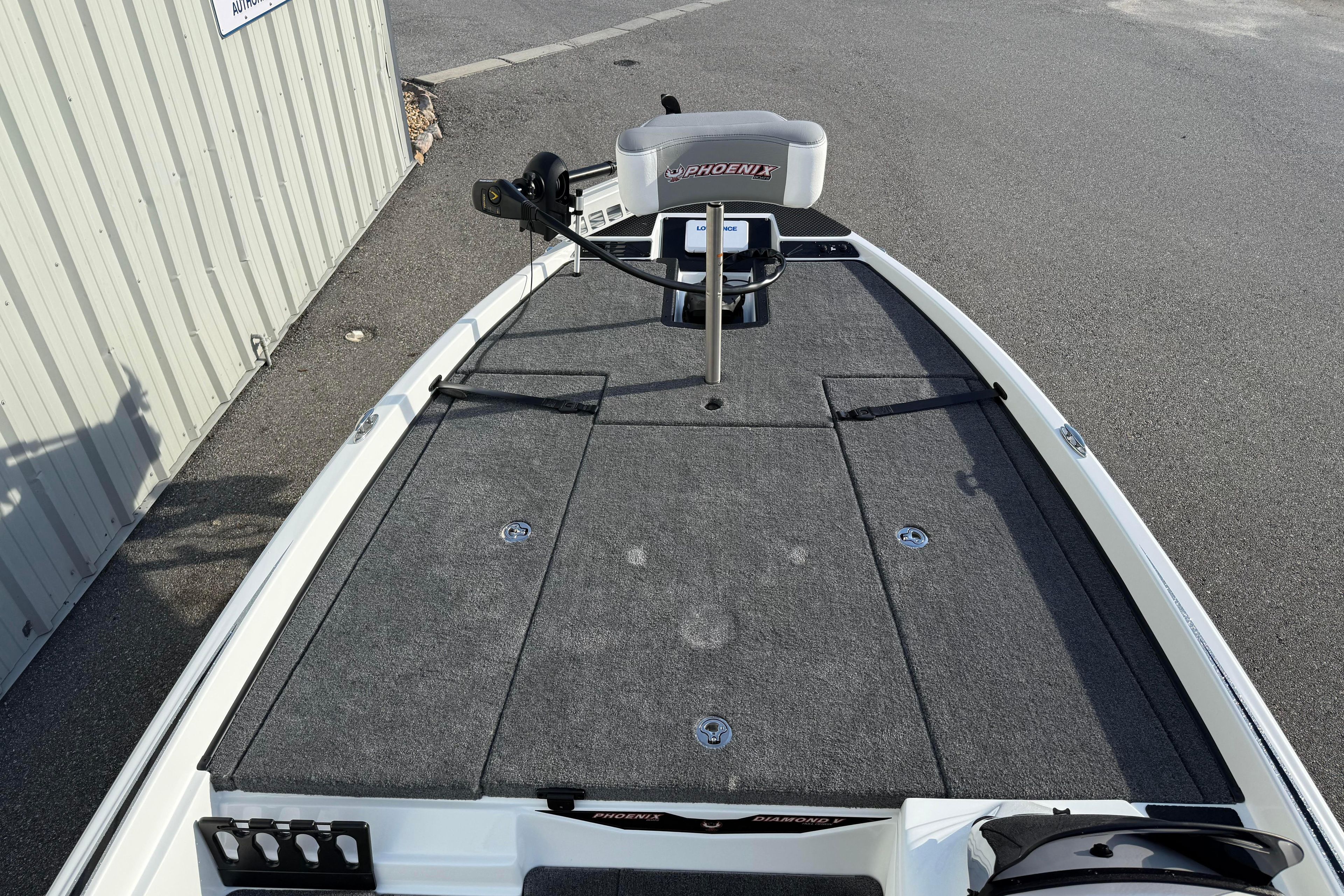 2027 Phoenix 721 ZXL boat deck with trolling motor, parked on pavement.
