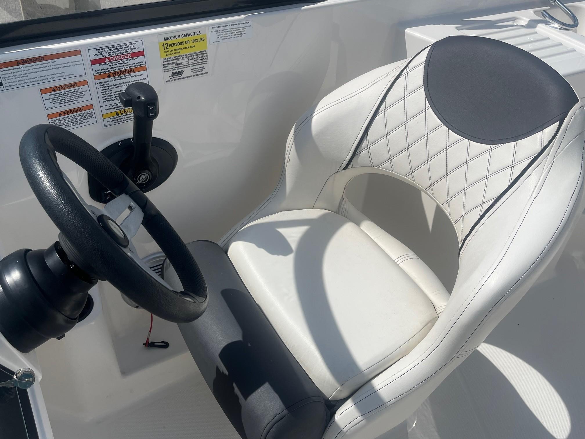 Steering wheel and seat of 2022 Bayliner DX 2200 boat cockpit.