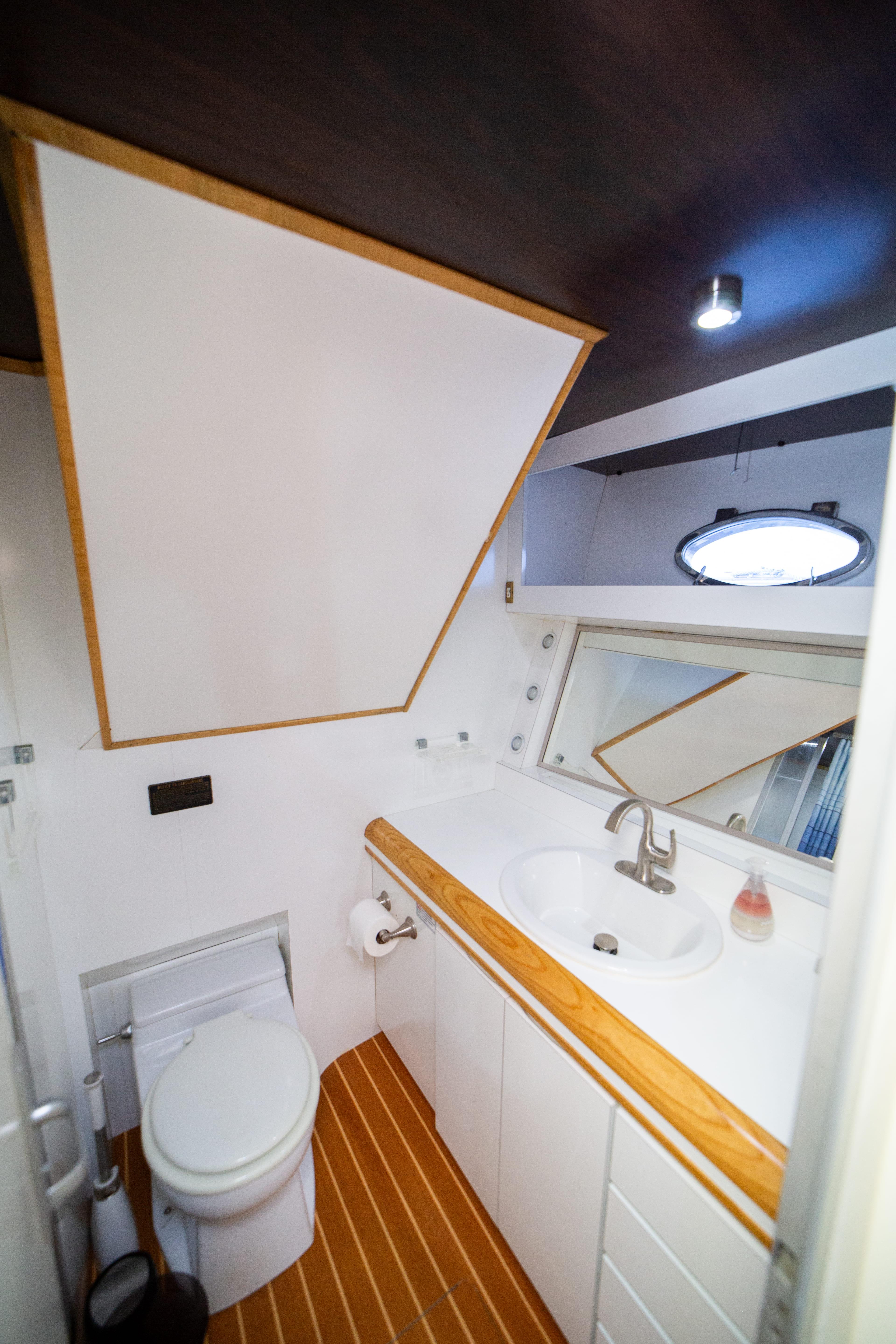 Luxurious bathroom in 1987 Guy Couach 97 yacht with modern fixtures and wooden accents.