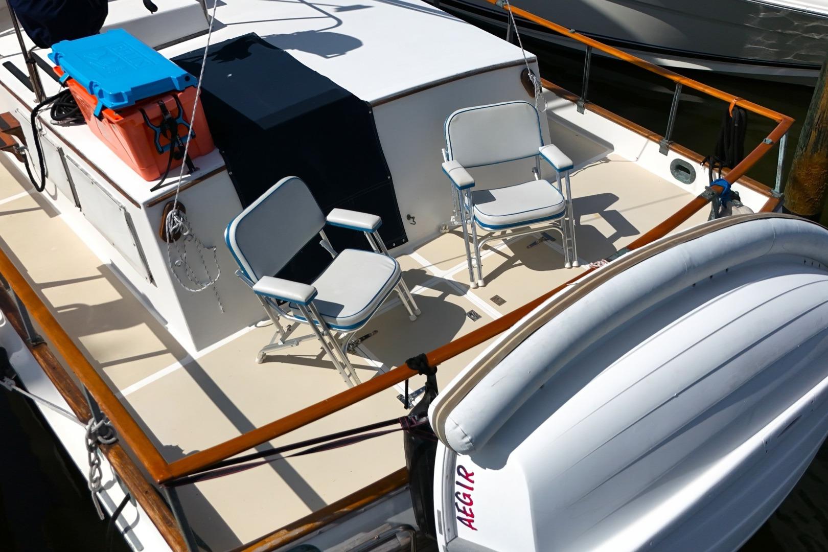 1978 Grand Banks 42 Classic yacht deck with chairs and inflatable boat.