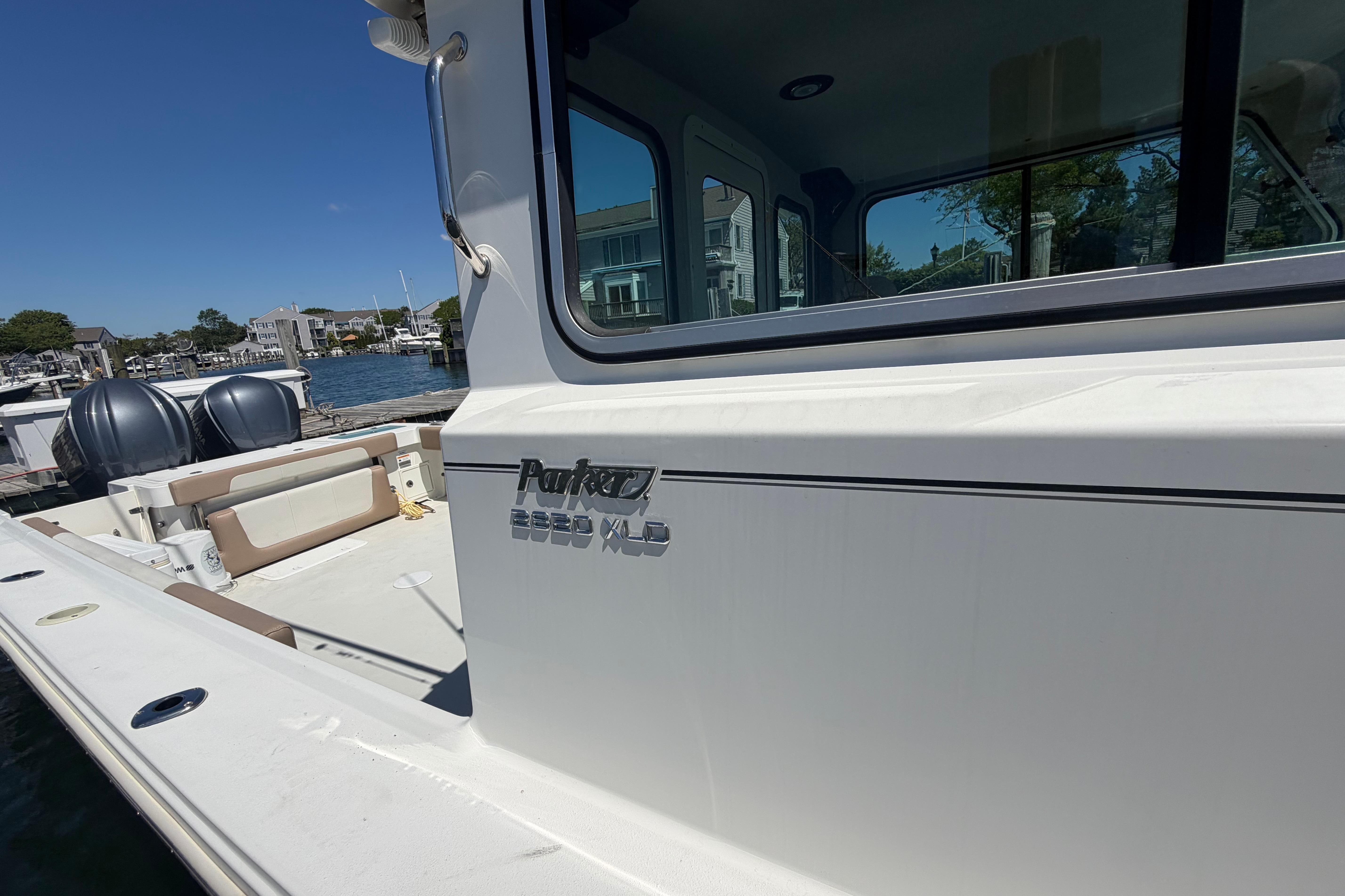 2019 Parker 2820 XLD Sport Cabin boat docked in a marina under clear skies.