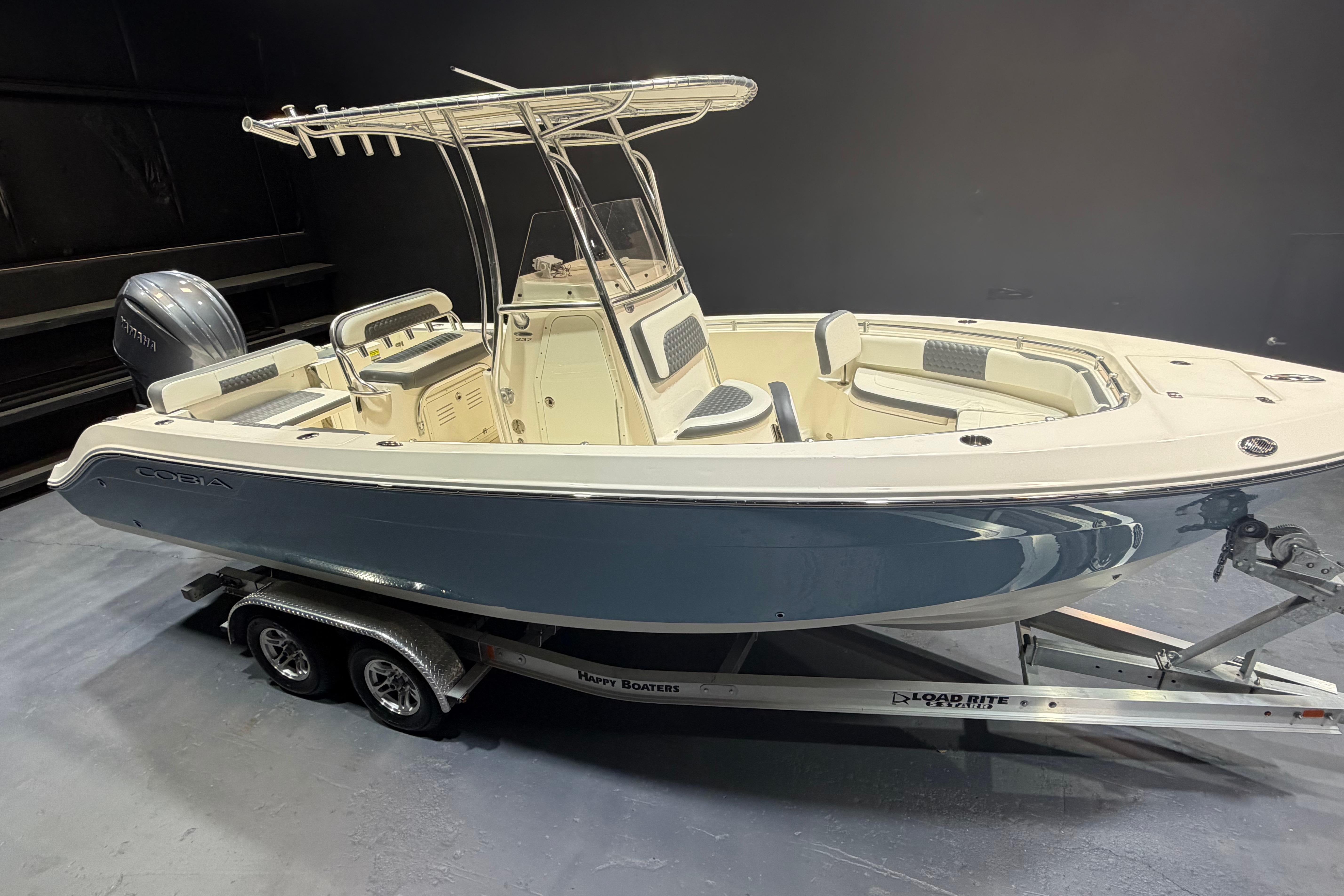 2023 Cobia 237 Center Console boat on trailer in showroom setting.