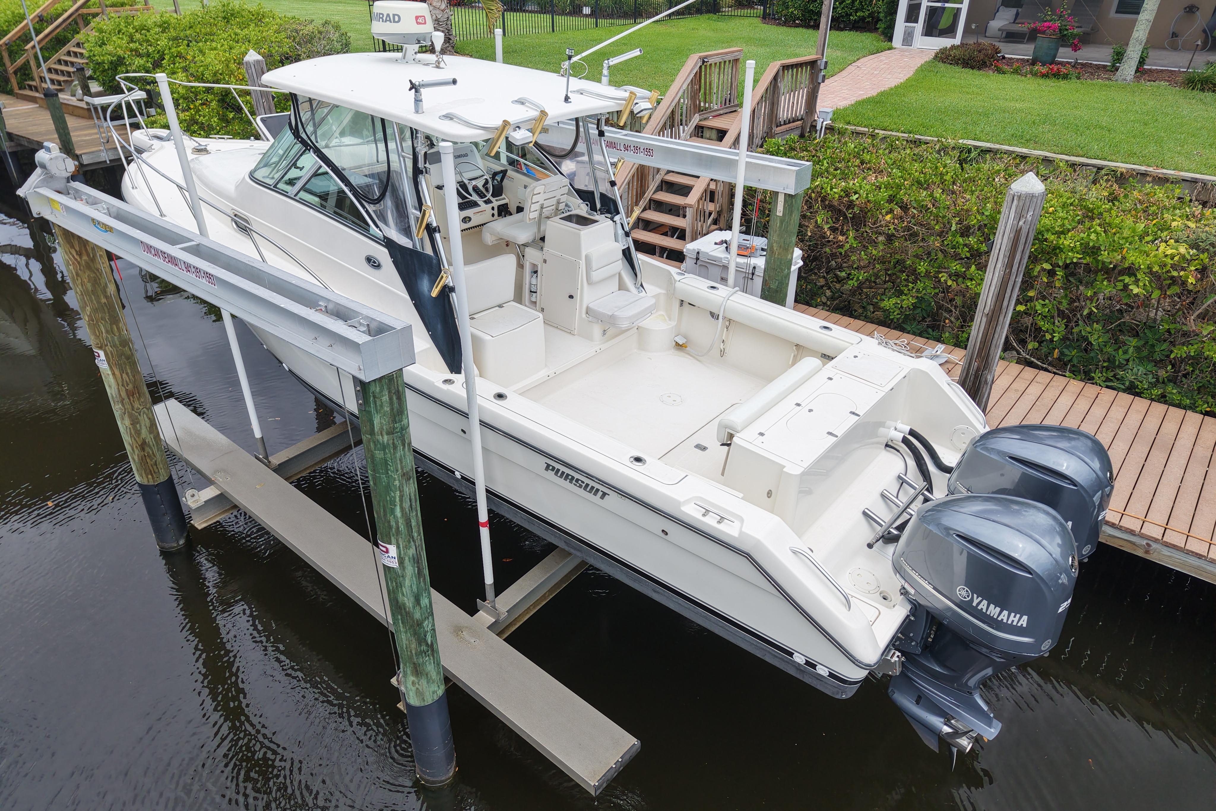 2005 Pursuit 3070 Offshore boat with dual Yamaha engines on a lift.