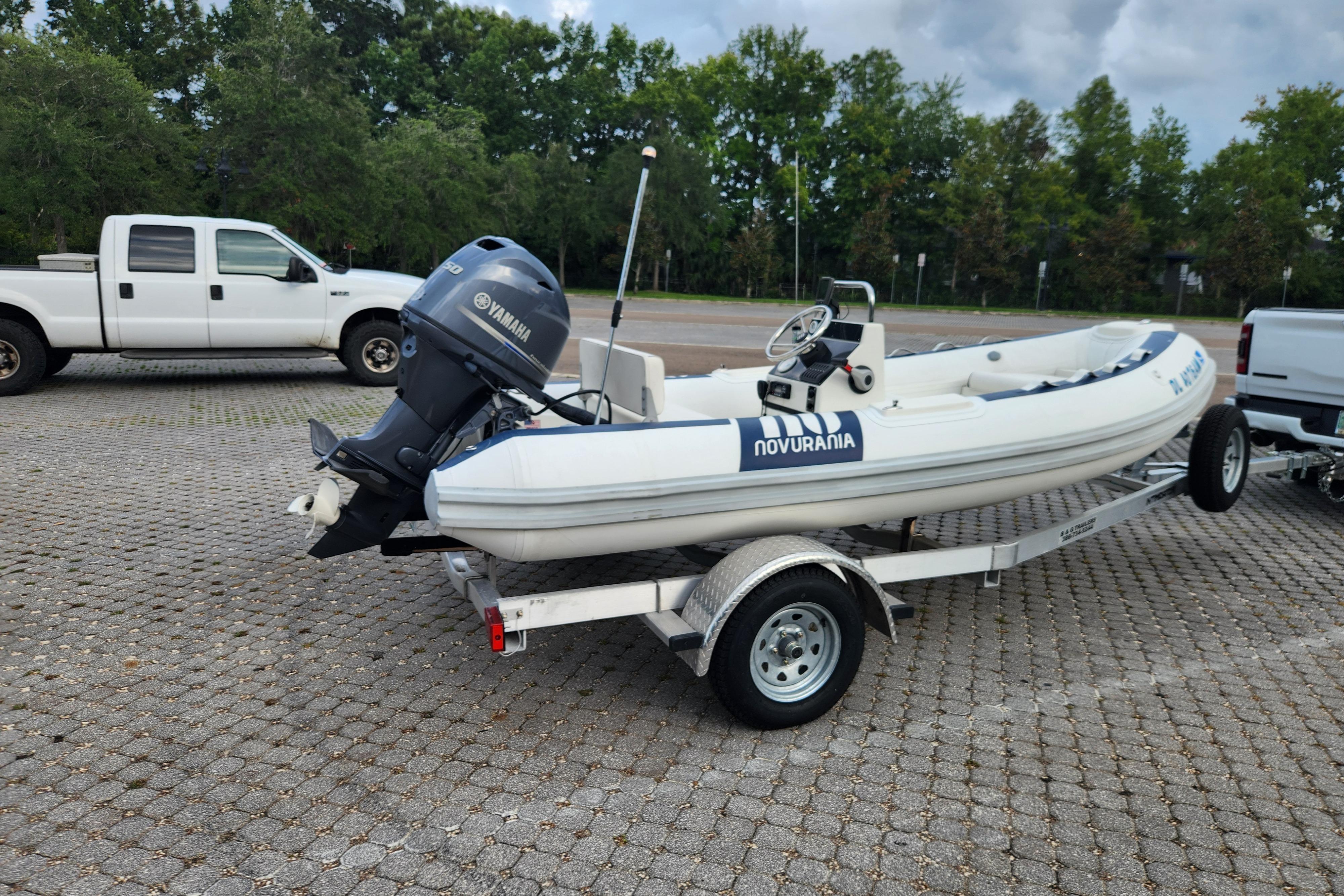 2019 Novurania DL 400 boat on trailer with Yamaha outboard motor in parking lot.