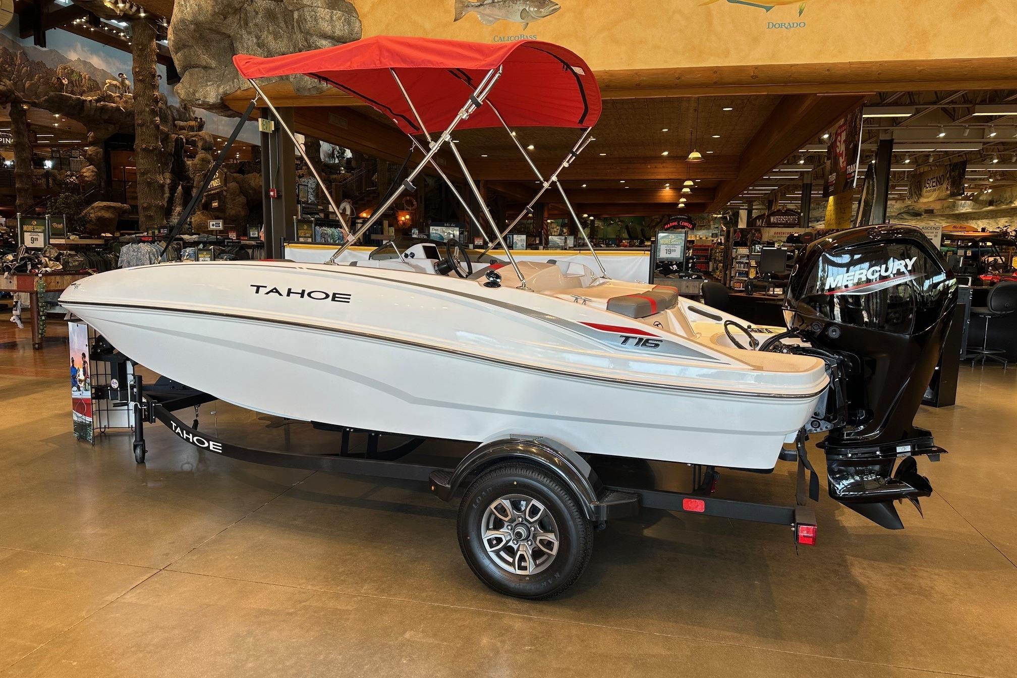 2025 Tahoe T16 boat with red canopy and Mercury engine on display indoors.