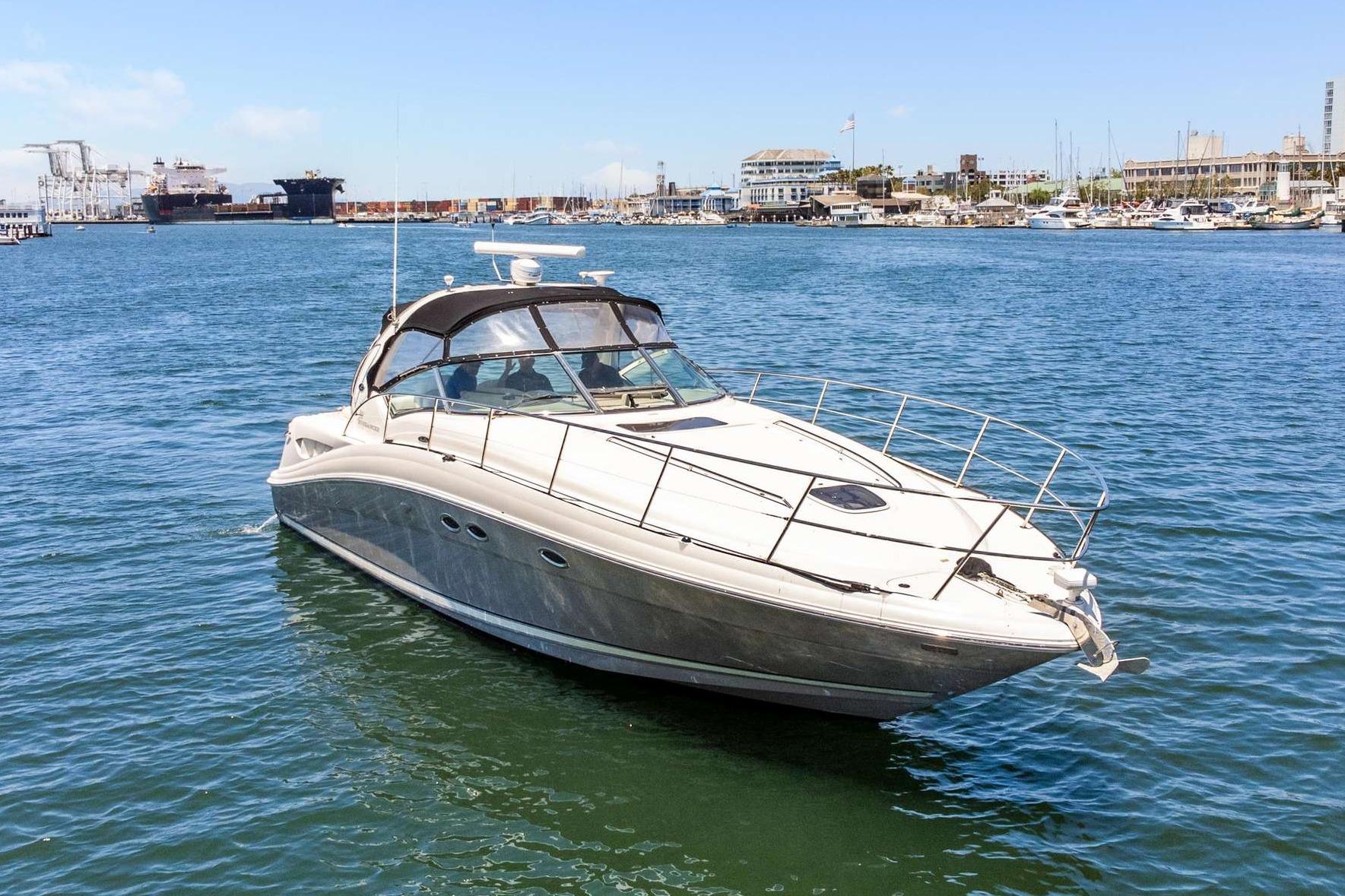 2005 Sea Ray 390 Sundancer yacht on calm waters near a marina.
