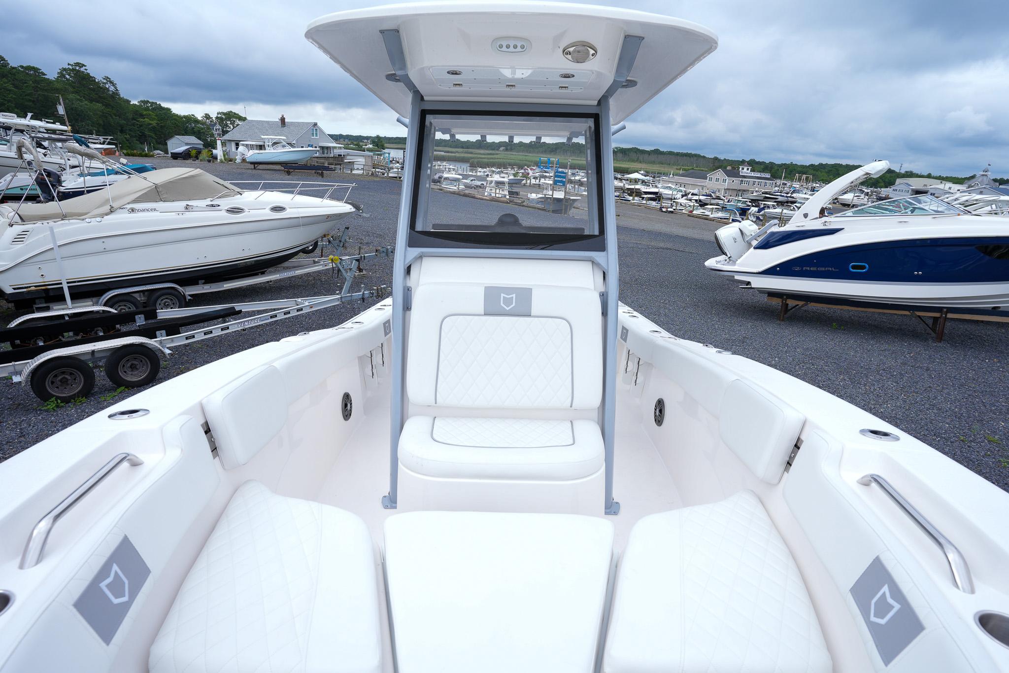 2026 Sea Fox 228 Commander boat interior with white seating, docked at a marina.