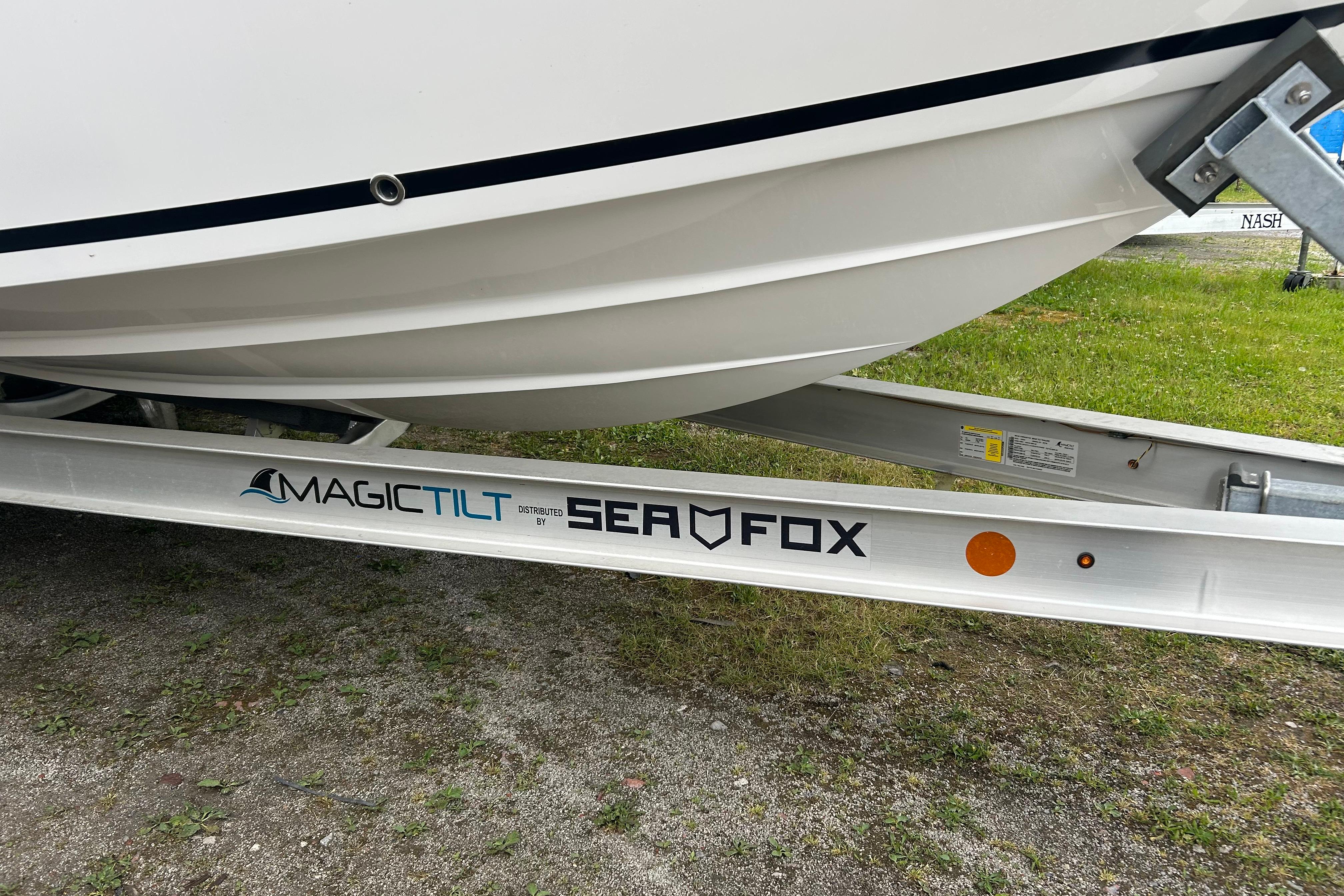 2026 Sea Fox 268 Commander boat on Magic Tilt trailer, parked on grass.