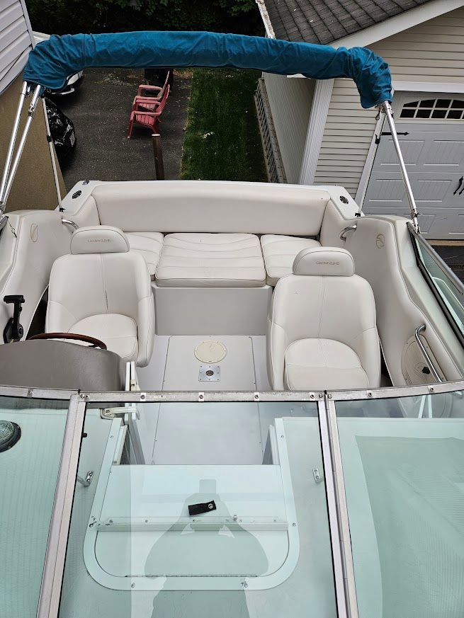 The image shows the cockpit of a 1998 Crownline 210 CCR boat with white seating.
