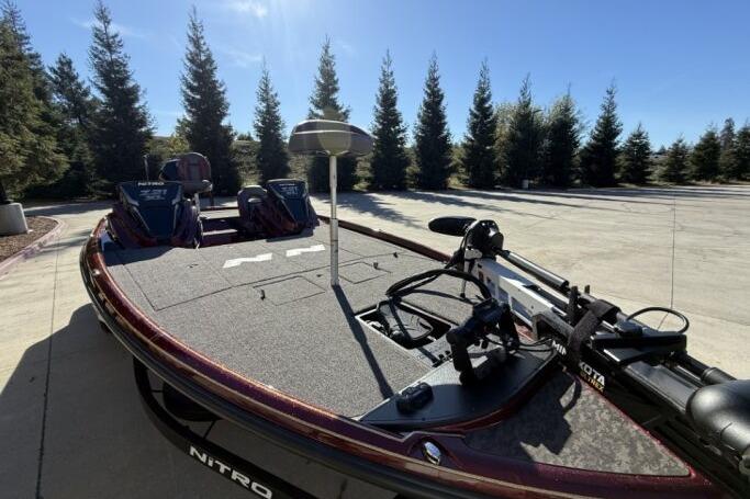 2026 Nitro Z21 XL Pro boat with fishing gear, parked outdoors near trees.