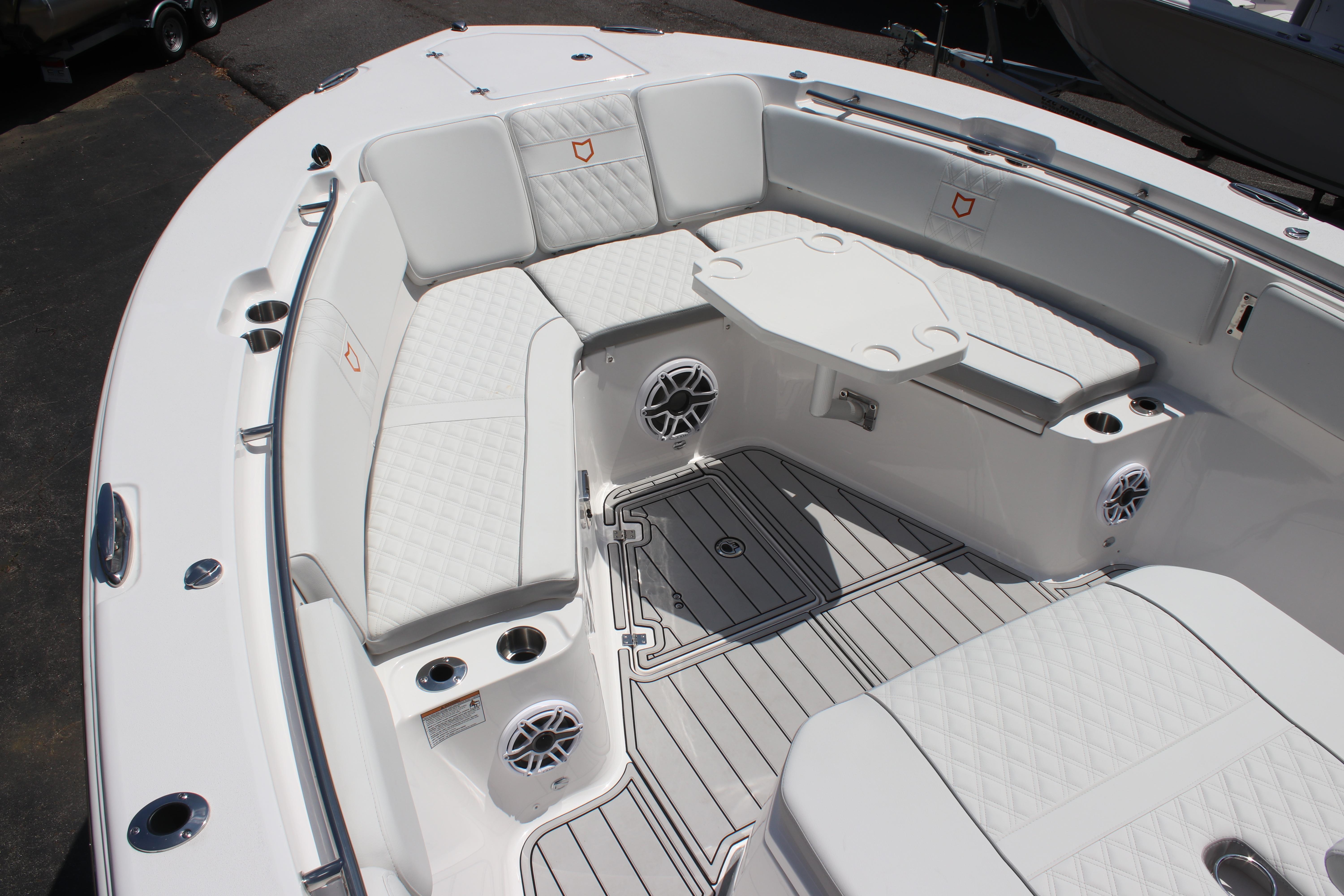 Luxurious seating area on 2025 Sea Fox 328 Commander boat with white upholstery and table.