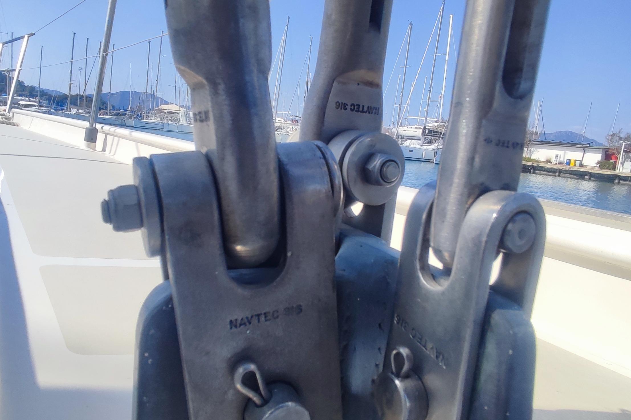 Close-up of rigging hardware on a 1987 Custom Danish 44 sailboat, with marina background.