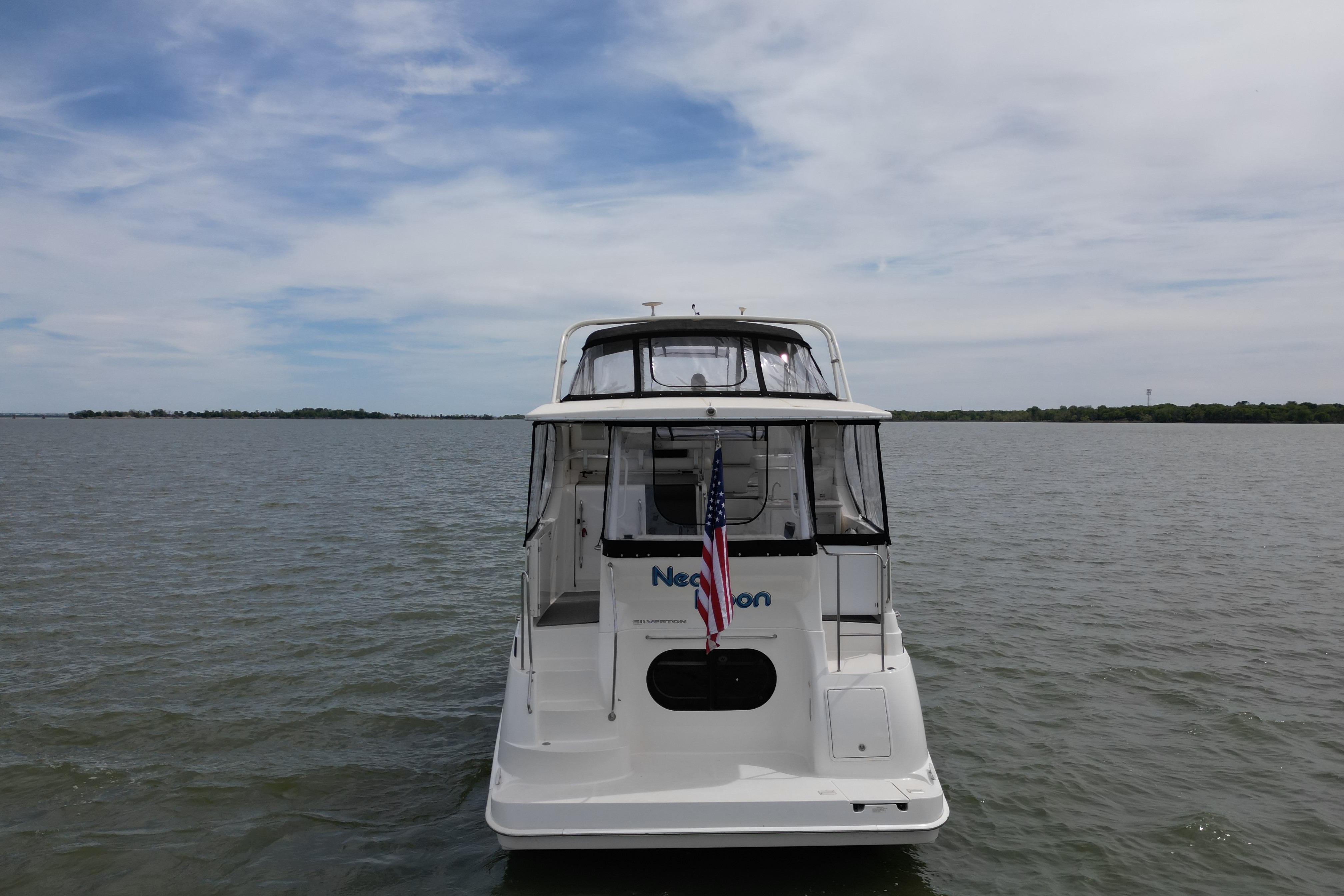 2003 Silverton 39 Motor Yacht on calm water, rear view with American flag.