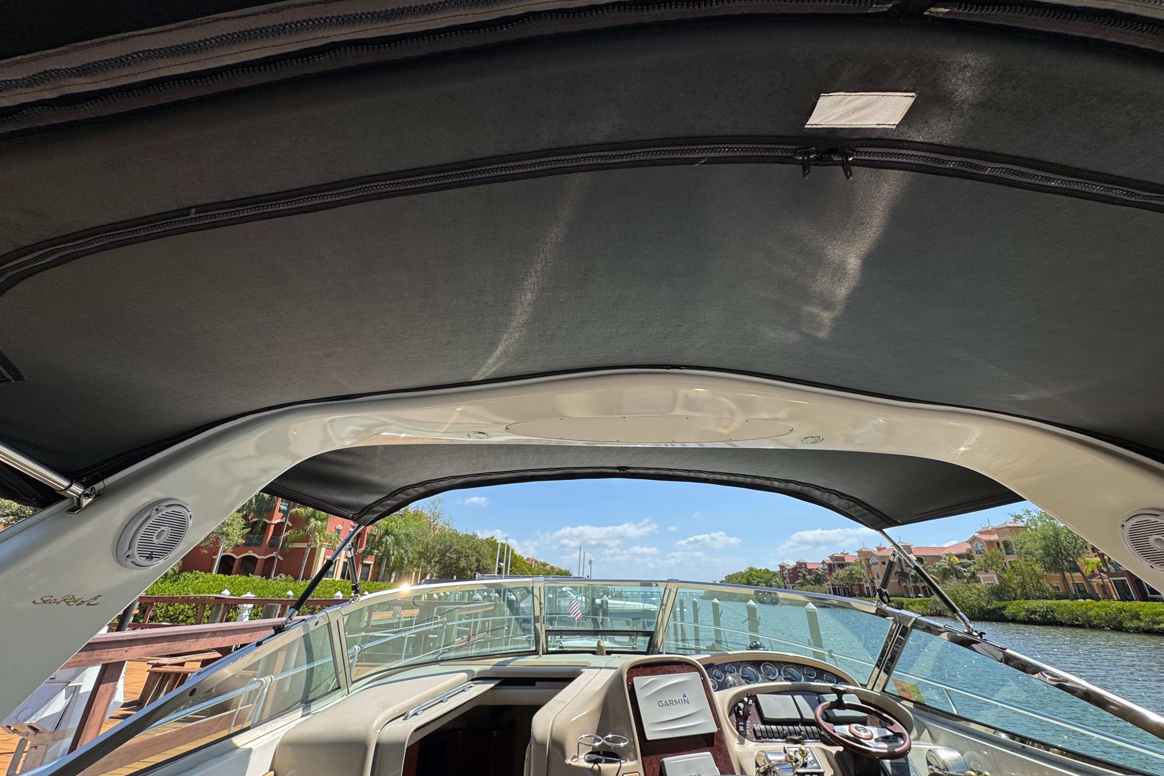 Cockpit view of 2002 Sea Ray 380 Sundancer yacht with canopy and waterfront scenery.